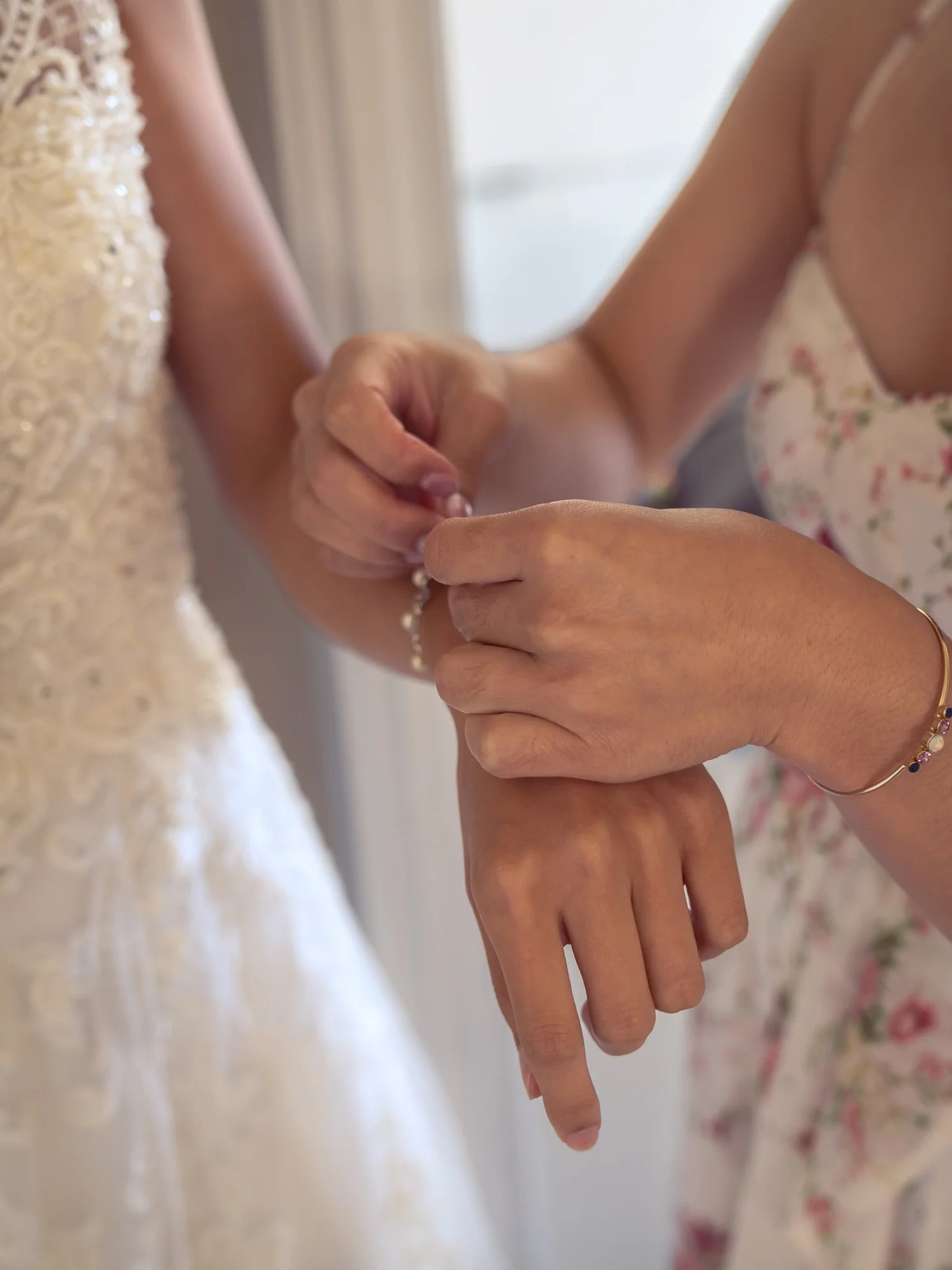 A bridesmaid fastens Gel's bracelet