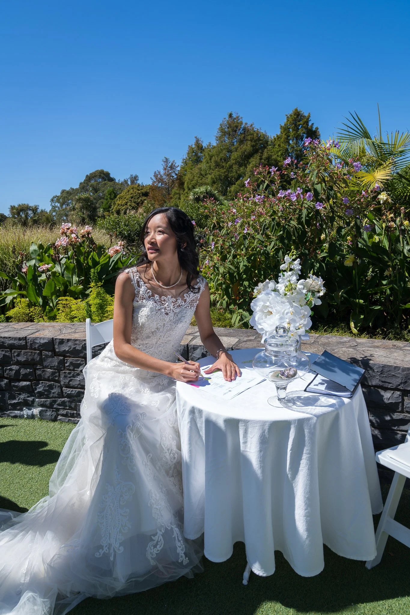 Gel signs the wedding register at a garden table