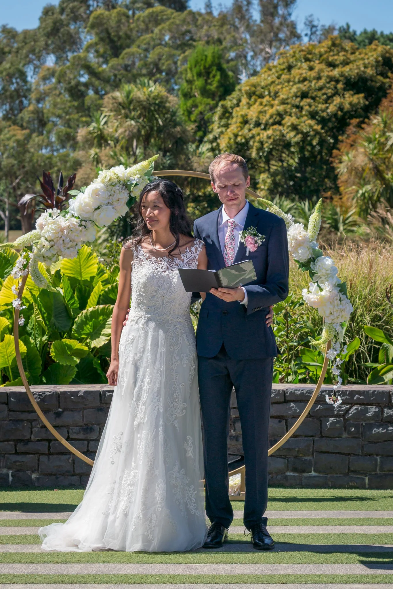 Gel and James beneath a floral hoop during the ceremony