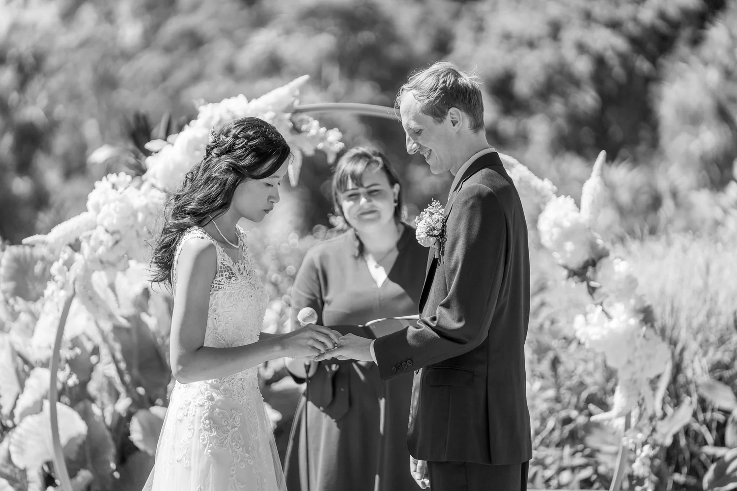 Black and white photo of Gel and James exchanging rings