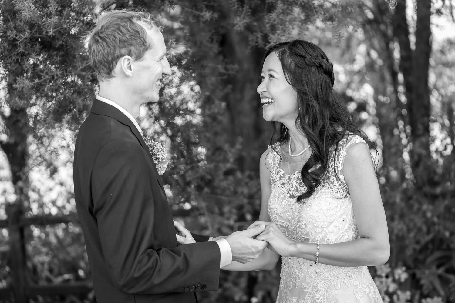 Black and white photo of Gel and James holding hands and laughing