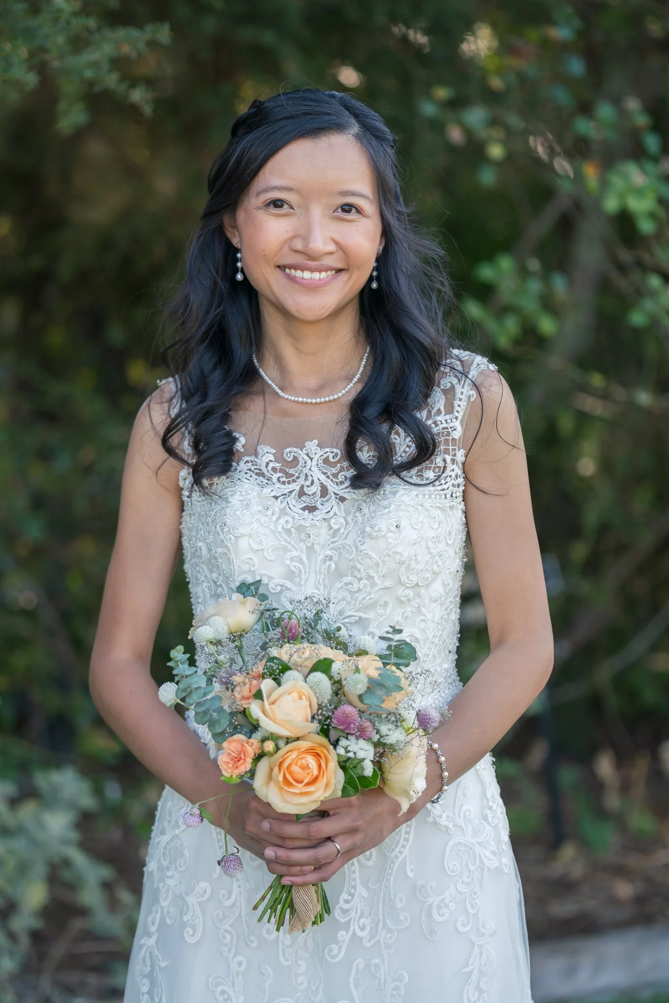 Portrait of Gel smiling with her bouquet