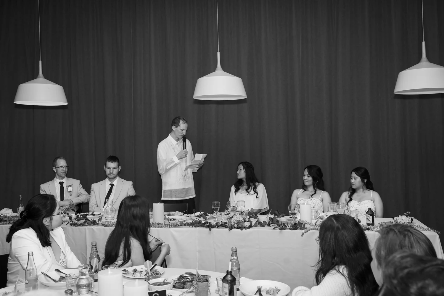 Black and white photo of the head table during the speeches