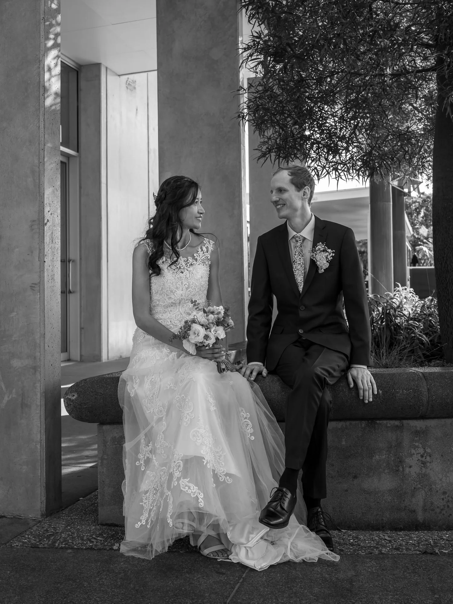 Black and white photo of Gel and James sitting together on a bench