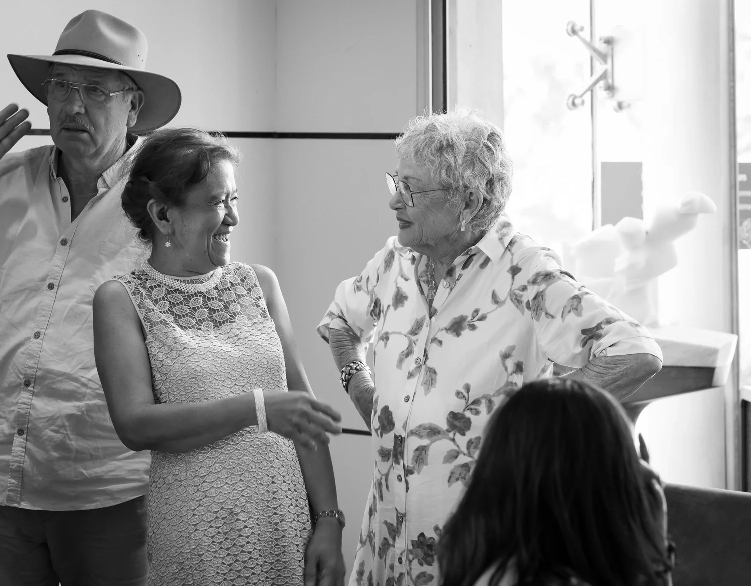 Black and white photo of guests chatting at the reception