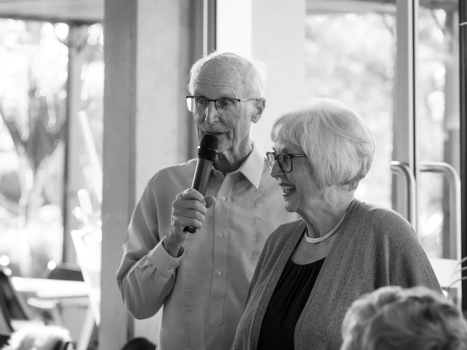 Black and white photo of two guests giving a speech