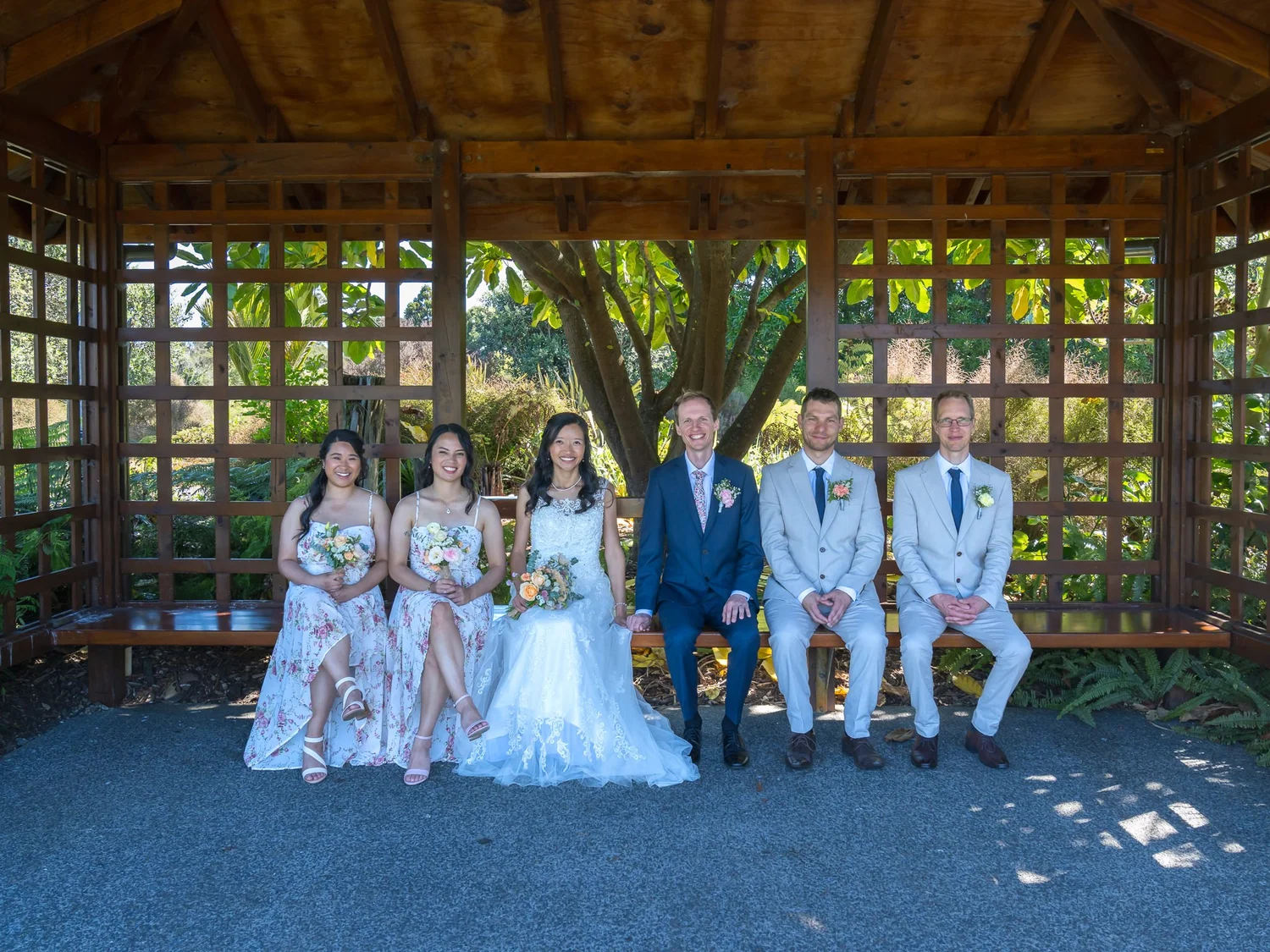Gel and James with their bridal party in a timber pavilion