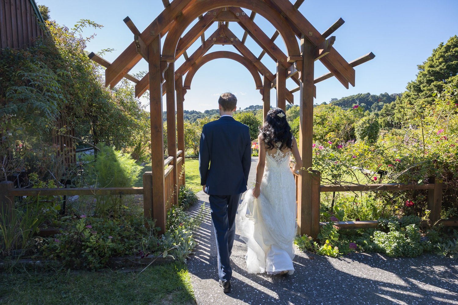 Gel and James walk under a wooden archway together