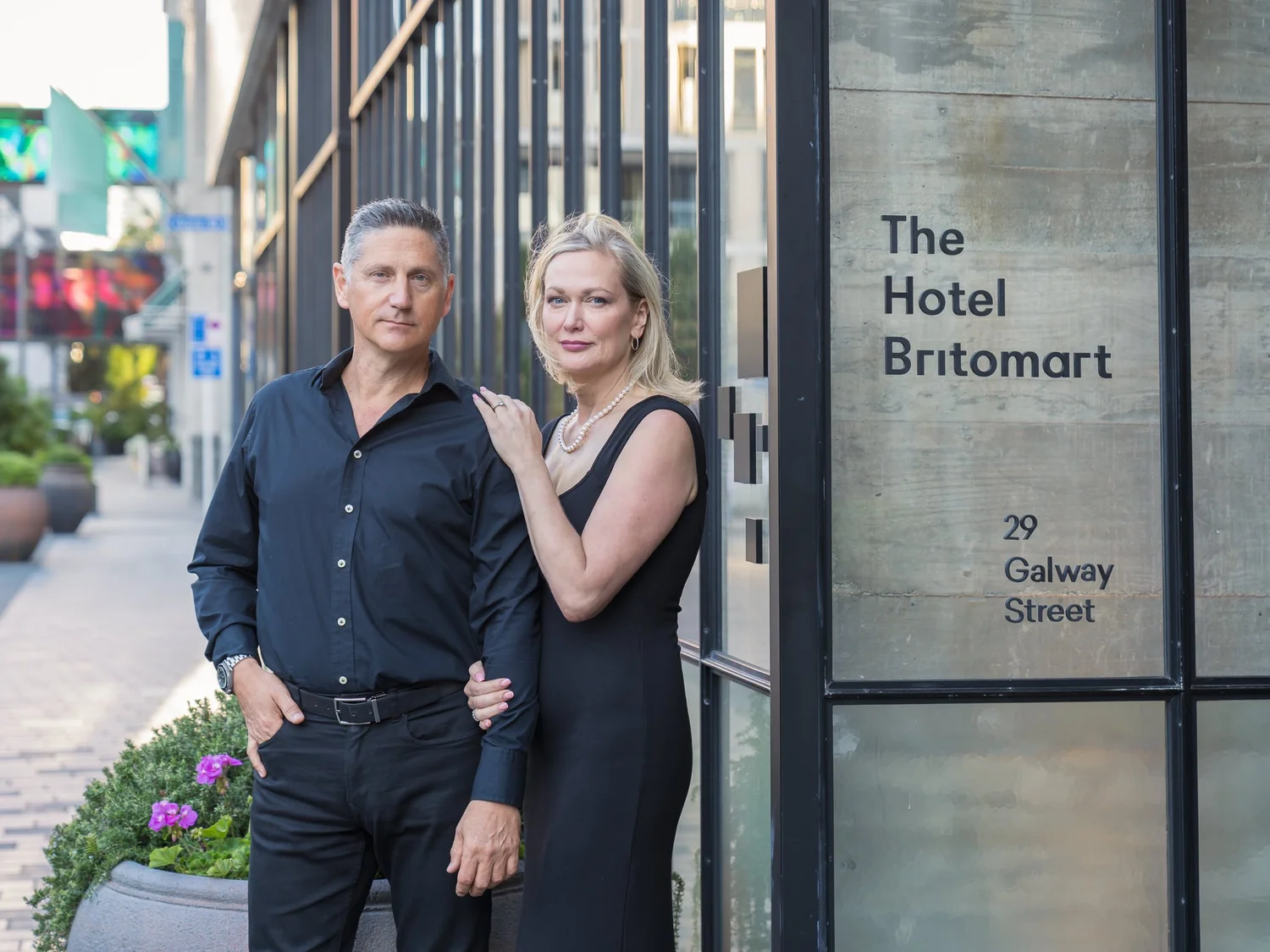 A couple pose beside The Hotel Britomart sign during their practice shoot