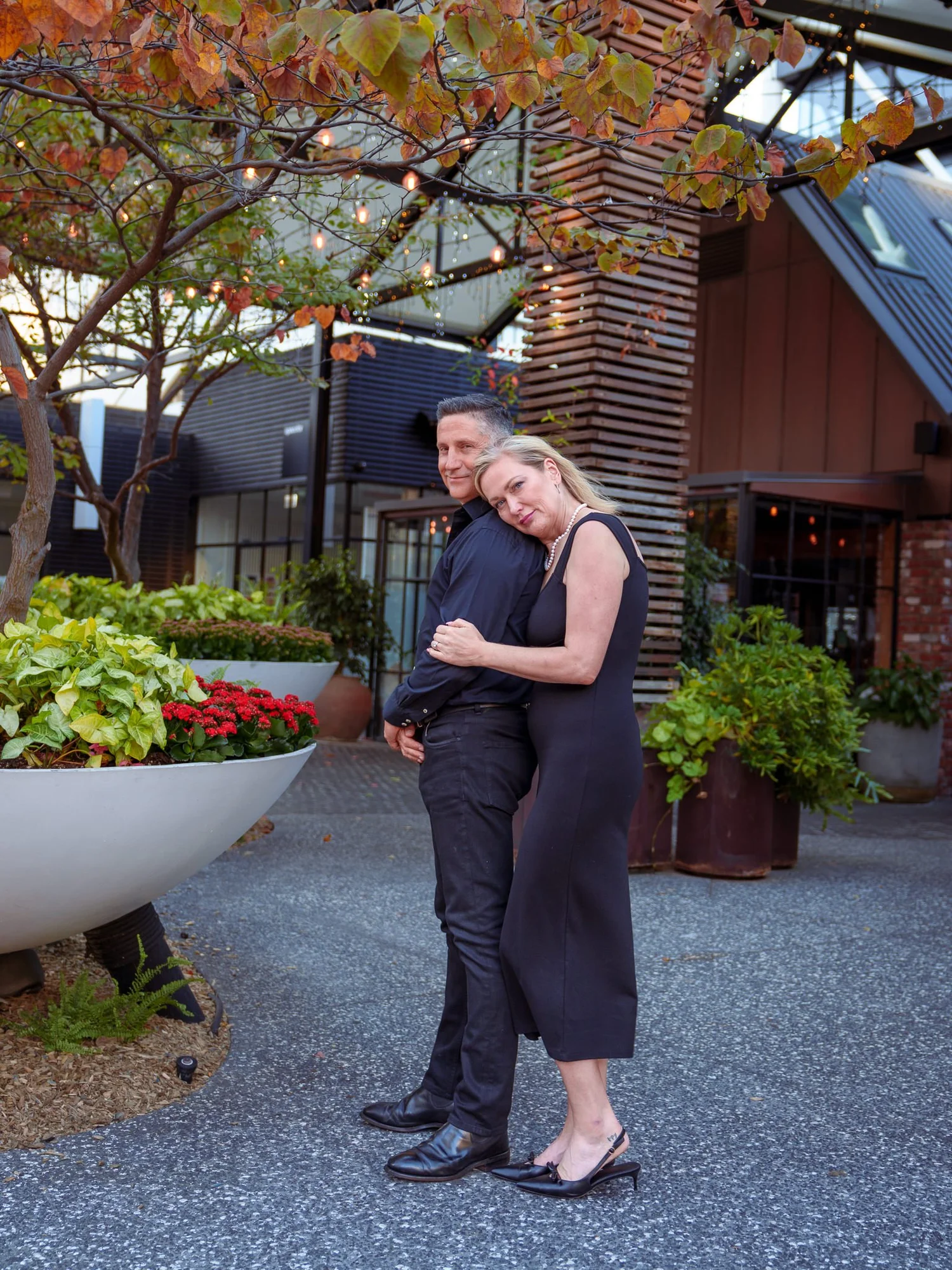 The couple beside planters in evening light