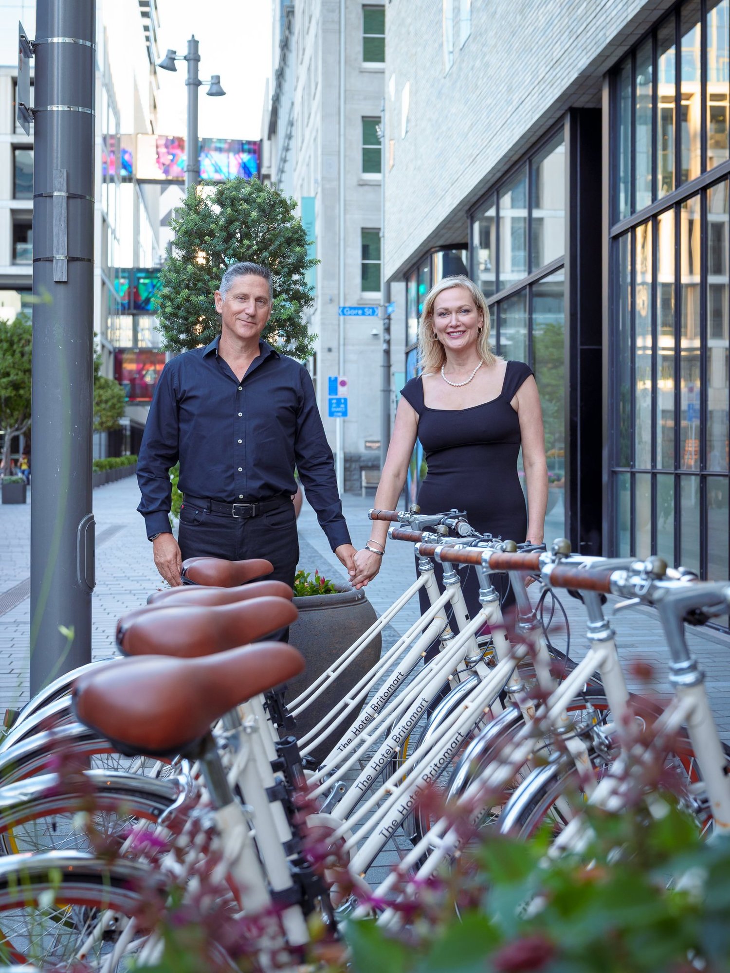 The couple stand beside a row of parked bicycles