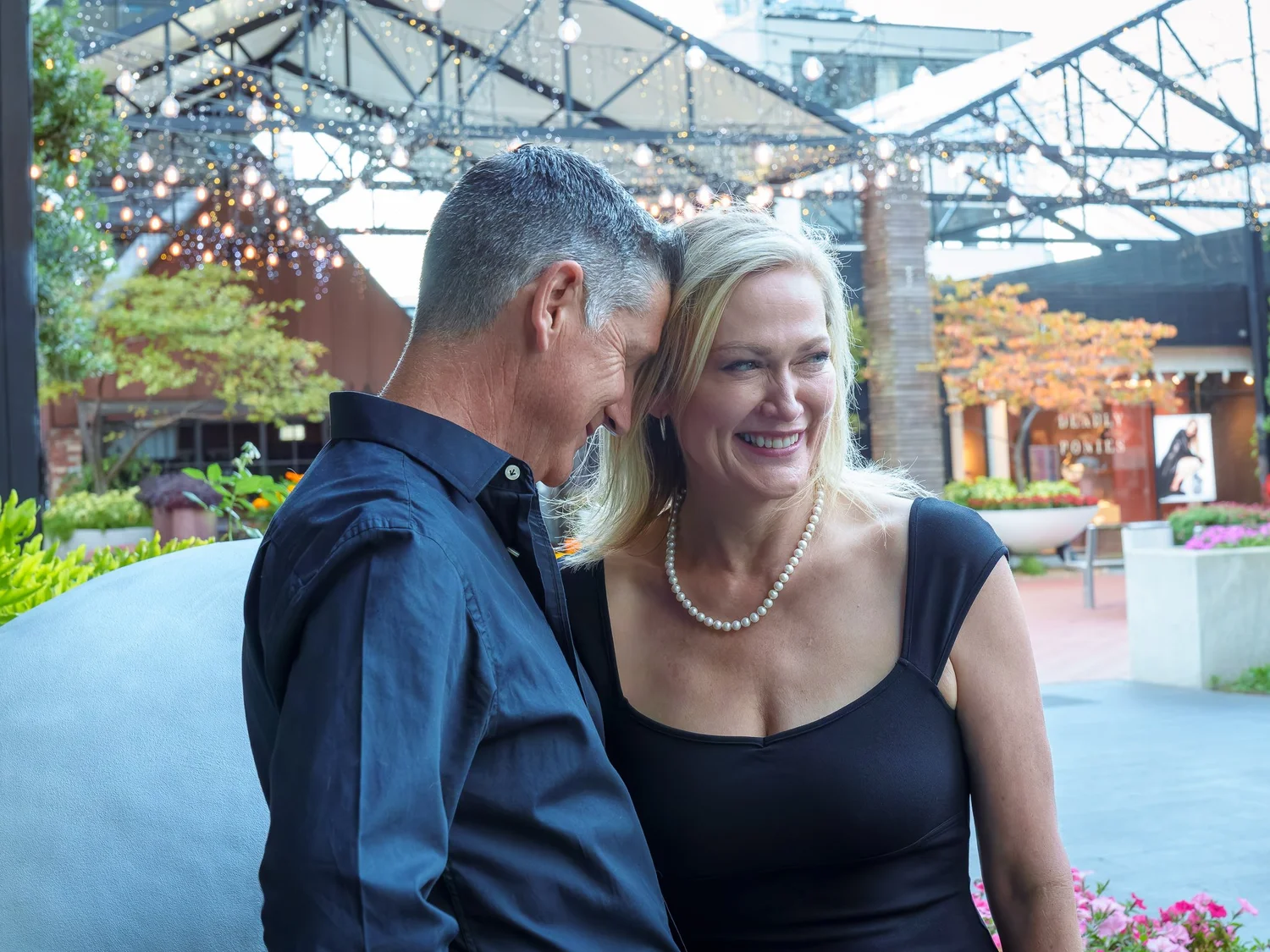 The couple share a quiet moment under a glass canopy