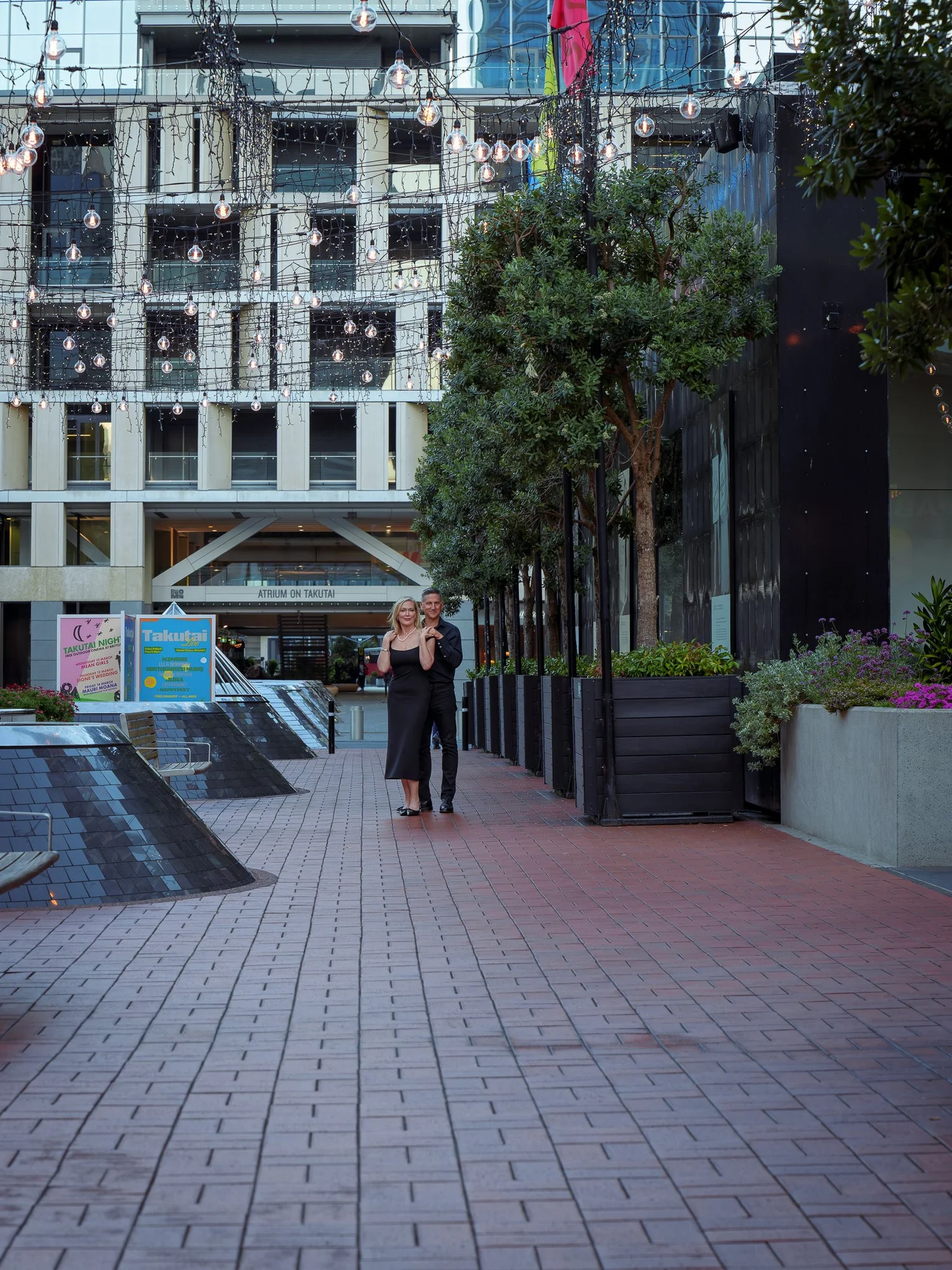 The couple walk away down a long brick-paved lane