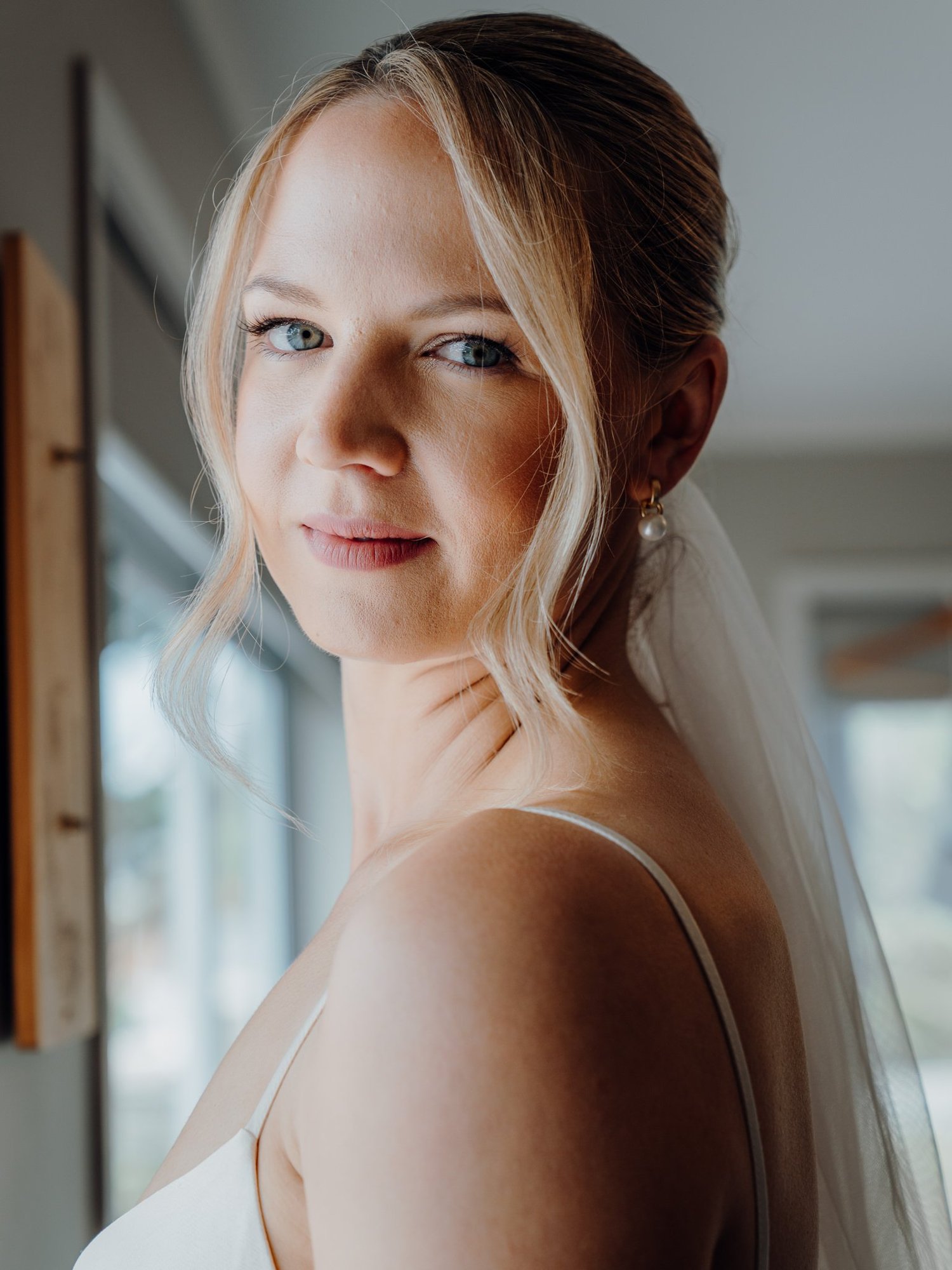 Rebecca smiles over her shoulder in her veil