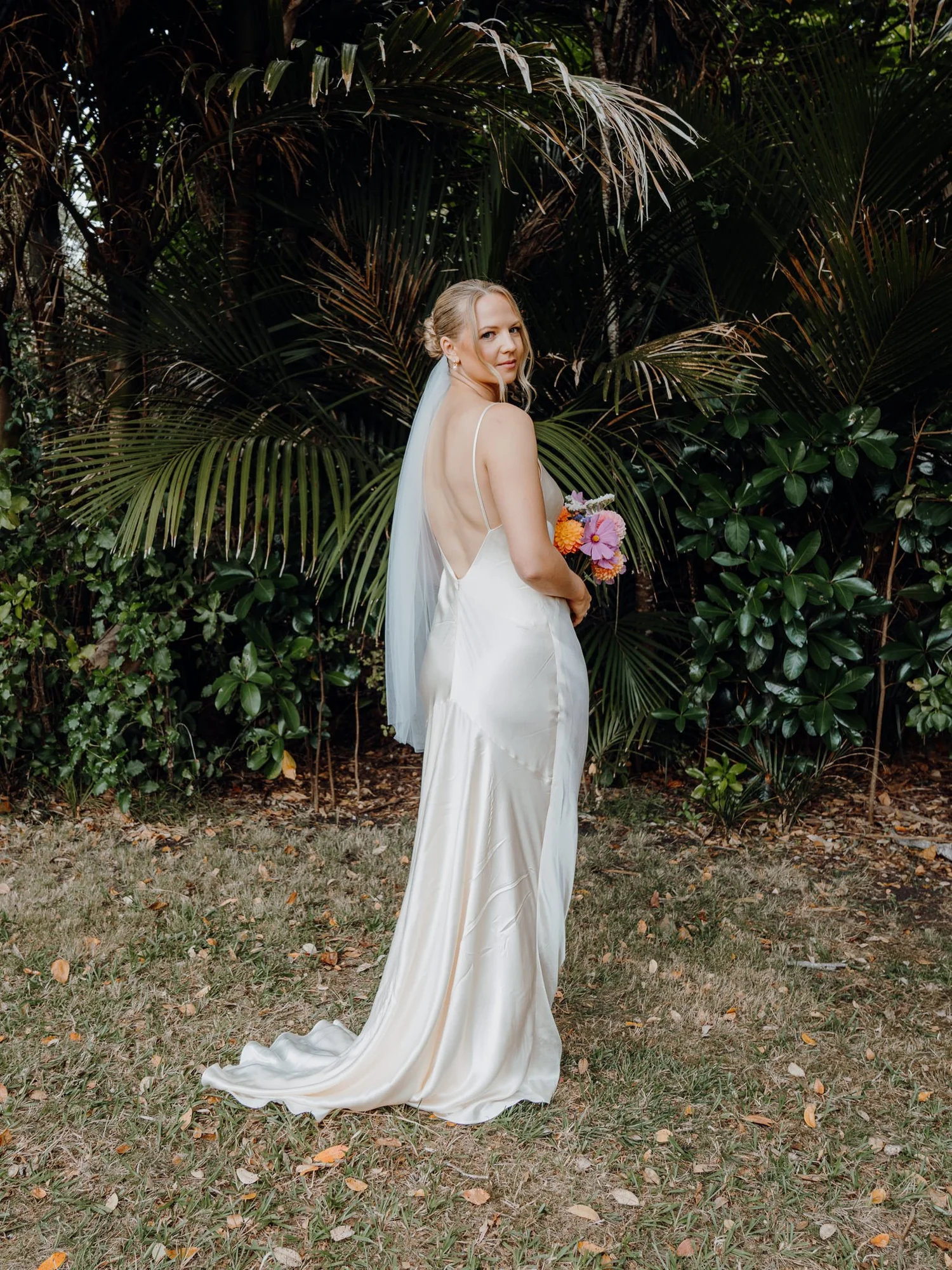 Rebecca in a satin gown among tropical plants