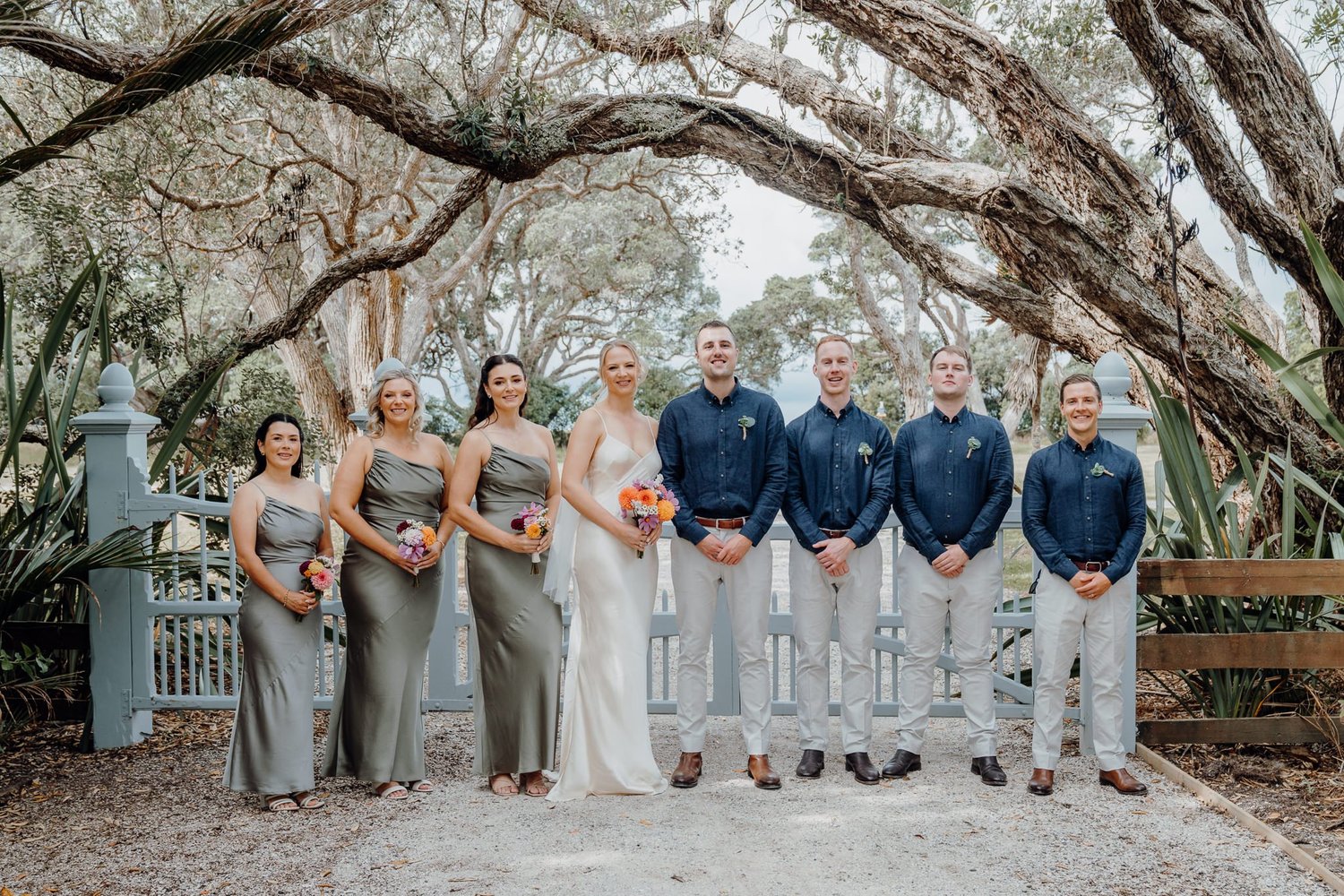The bridal party in front of Cauldrey House under the pōhutukawa