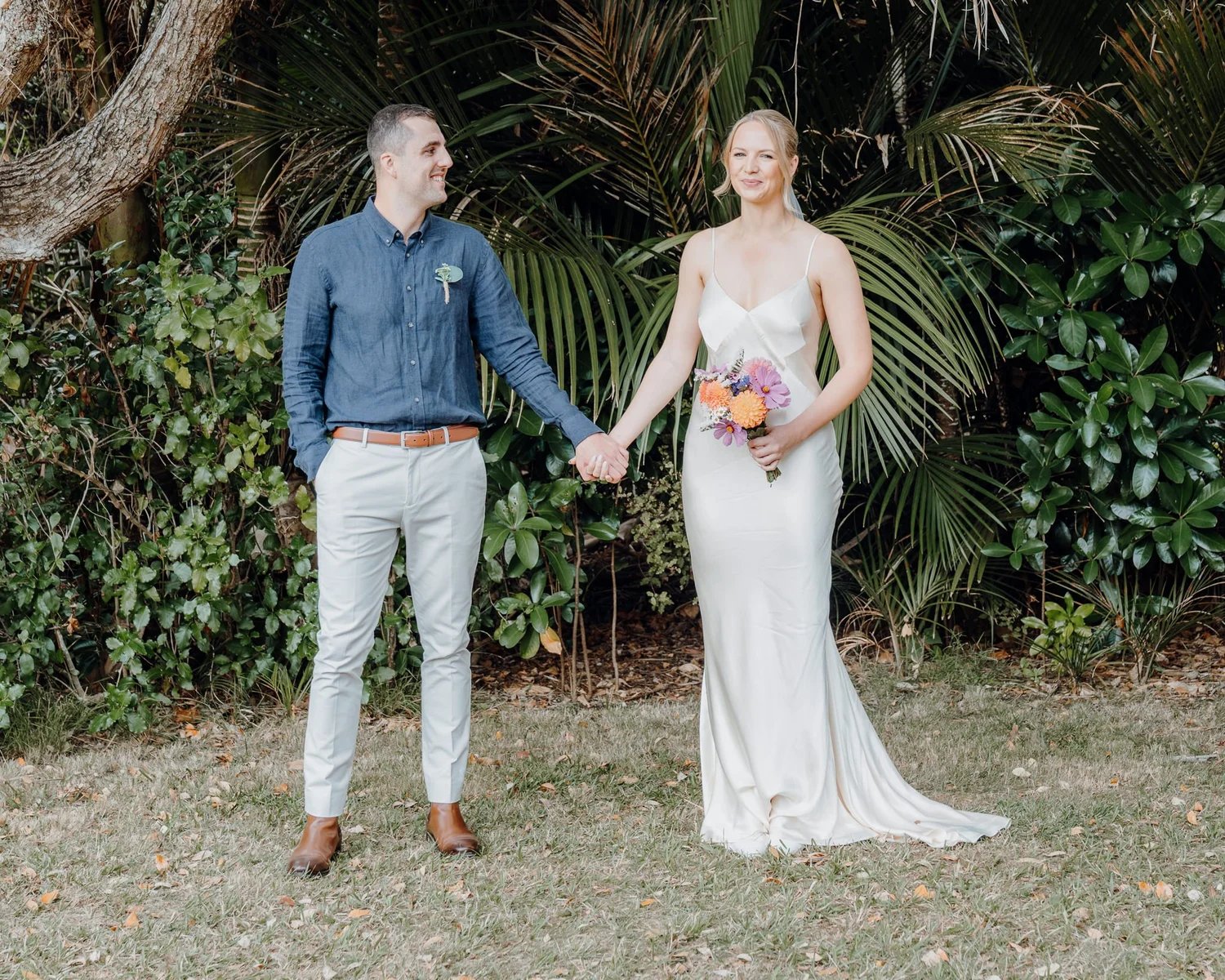Rebecca and Michael hold hands in front of the palms