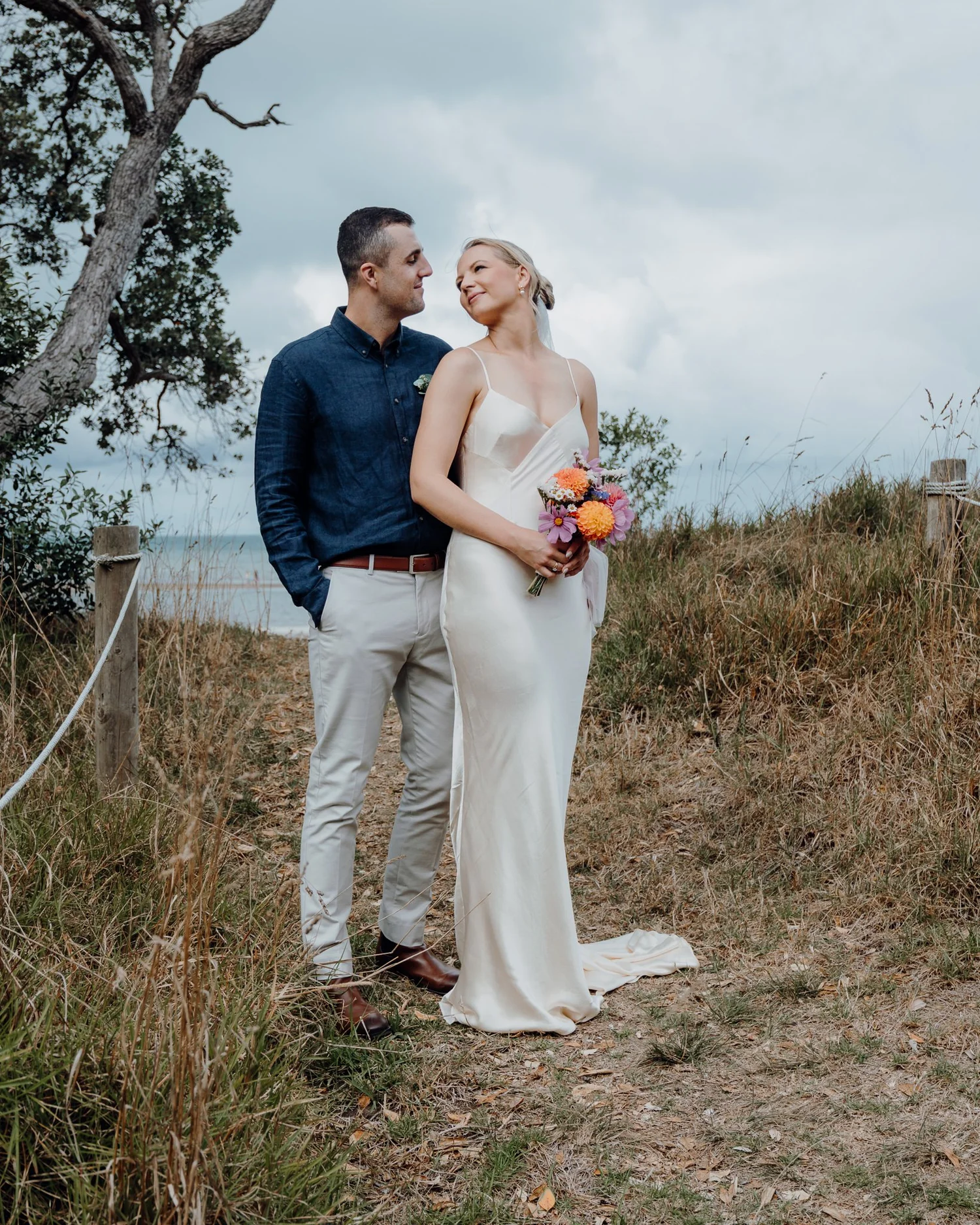 Rebecca and Michael stand together above the beach
