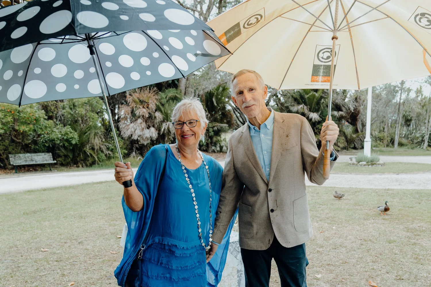 Two guests under spotted umbrellas