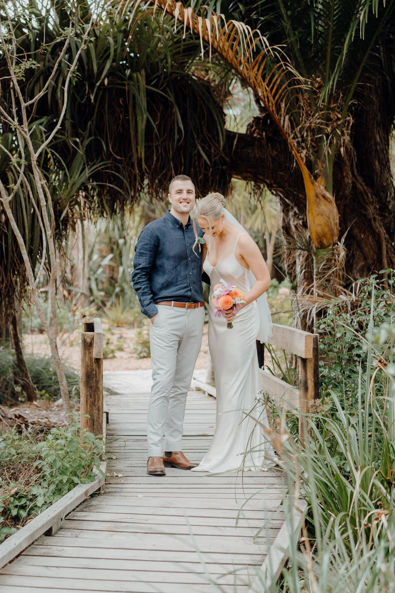 Rebecca and Michael on a boardwalk under a palm arch