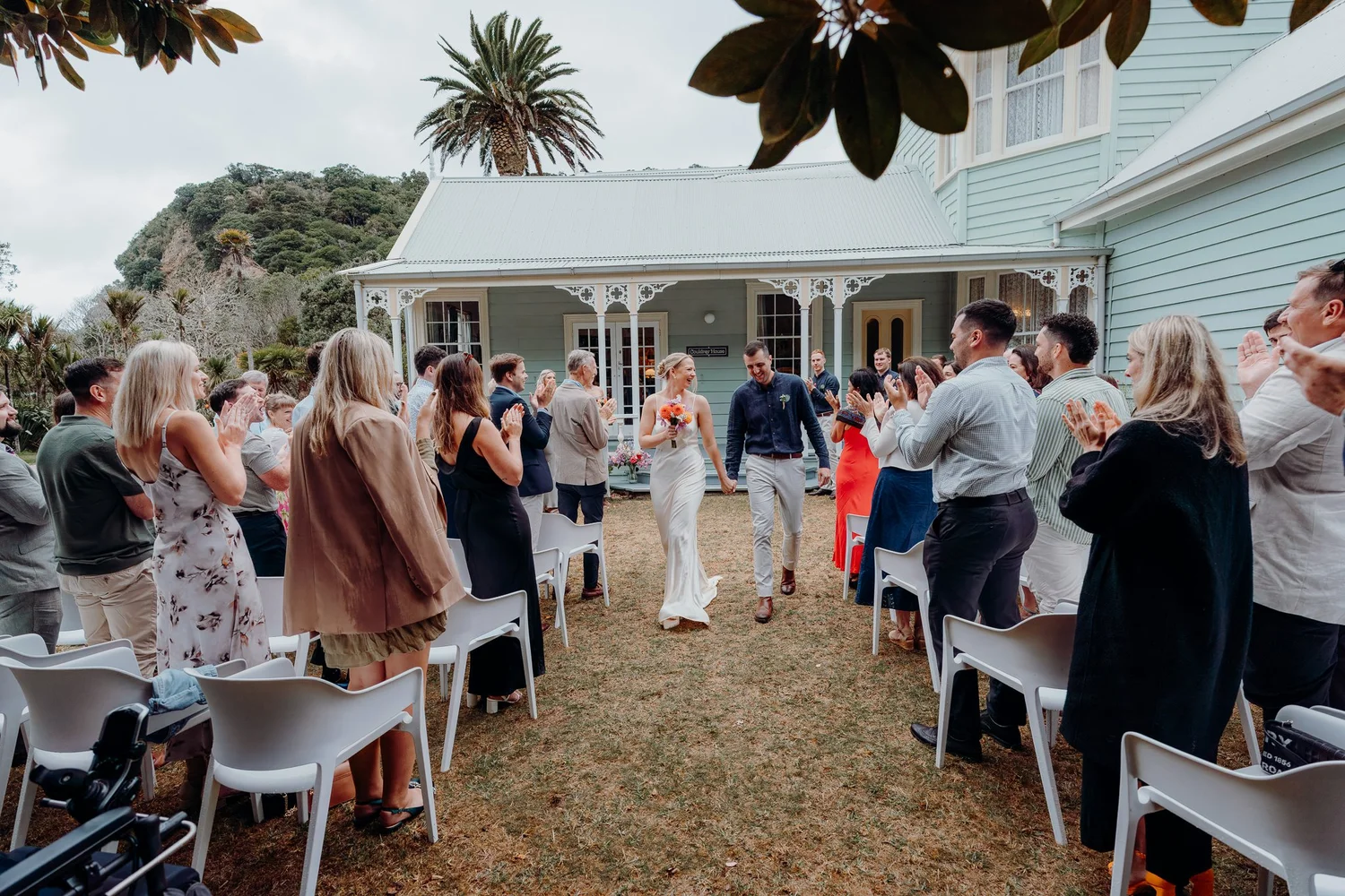 Guests cheer as Rebecca and Michael walk back up the aisle