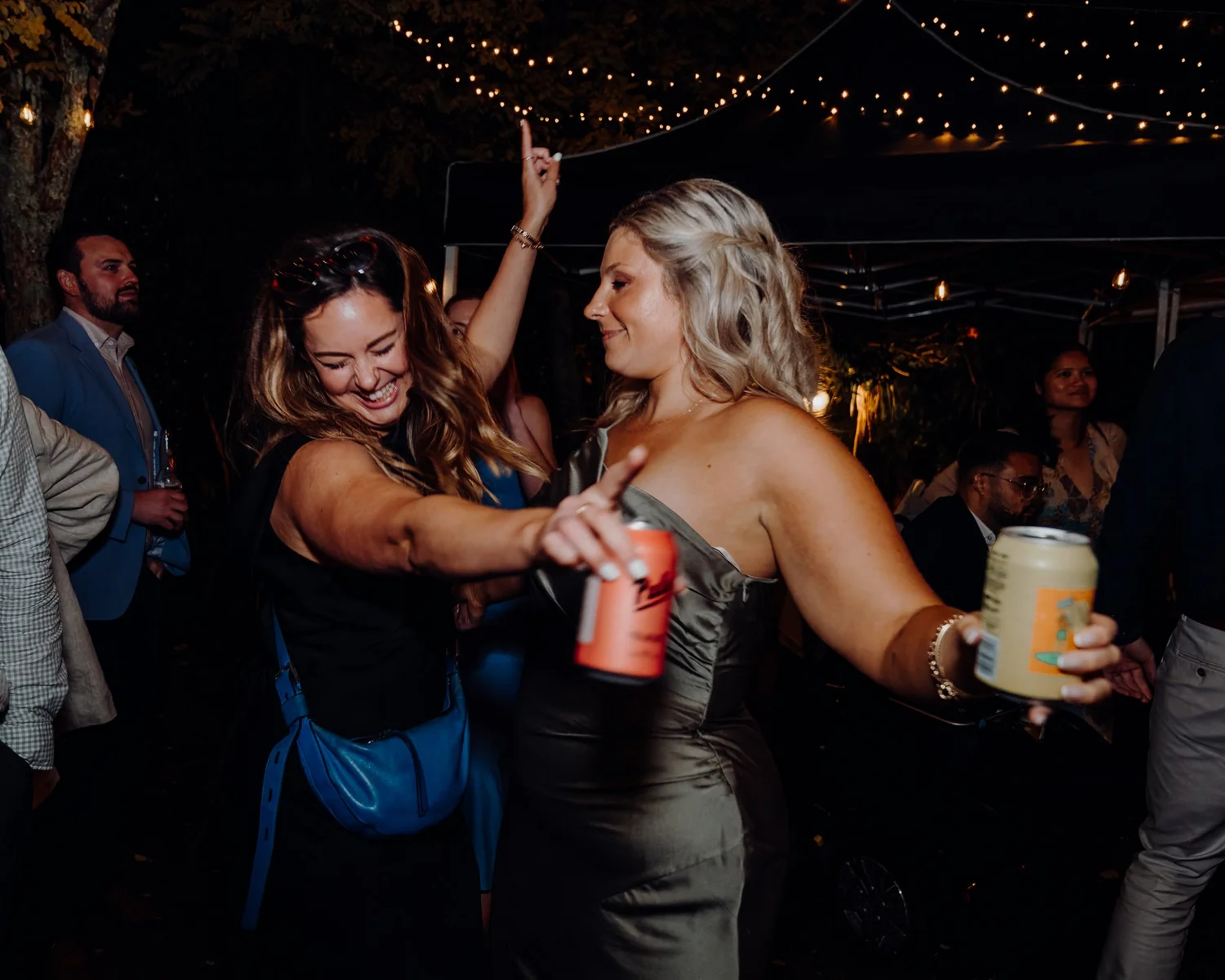Guests dance holding drinks
