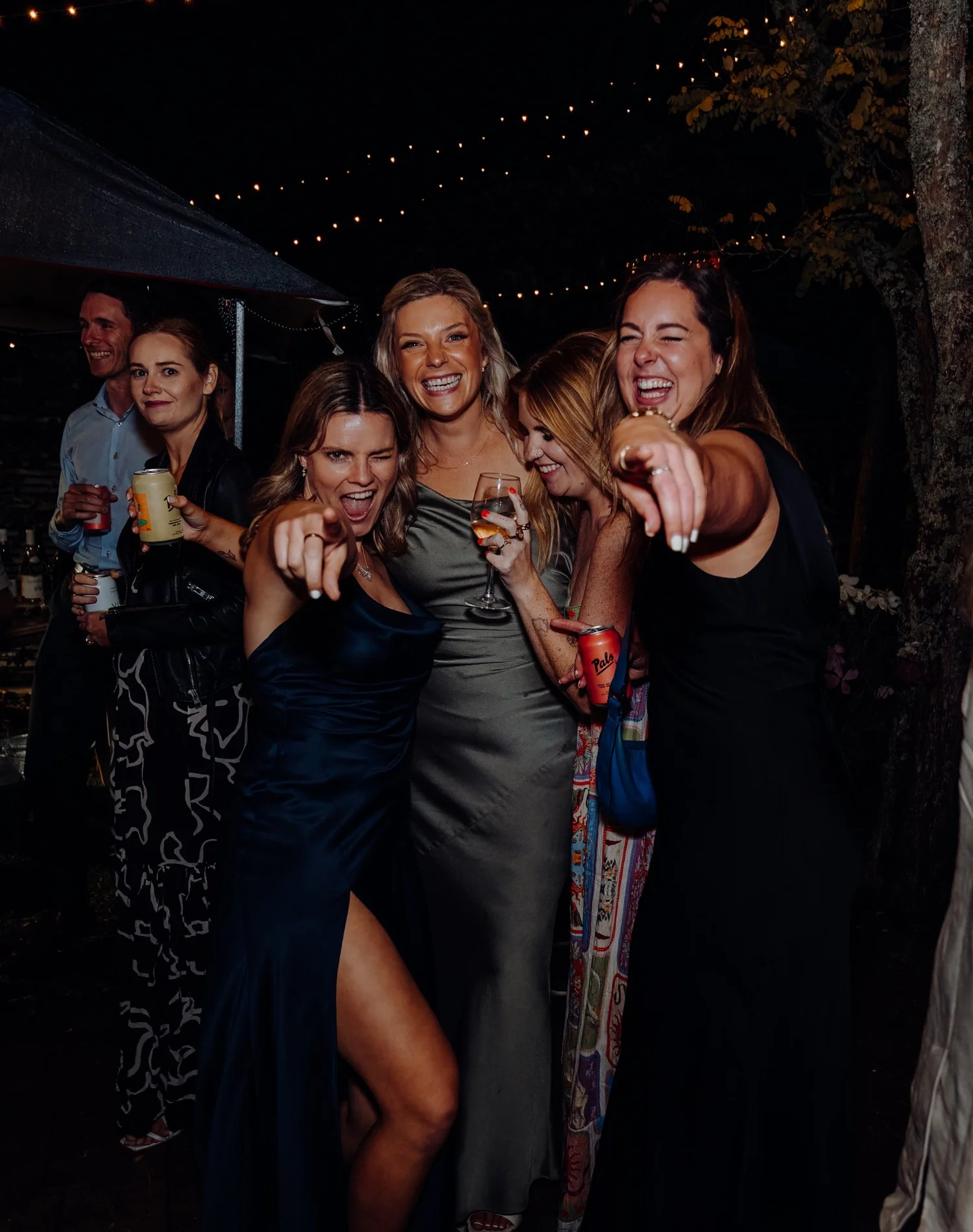 Guests point at the camera while dancing