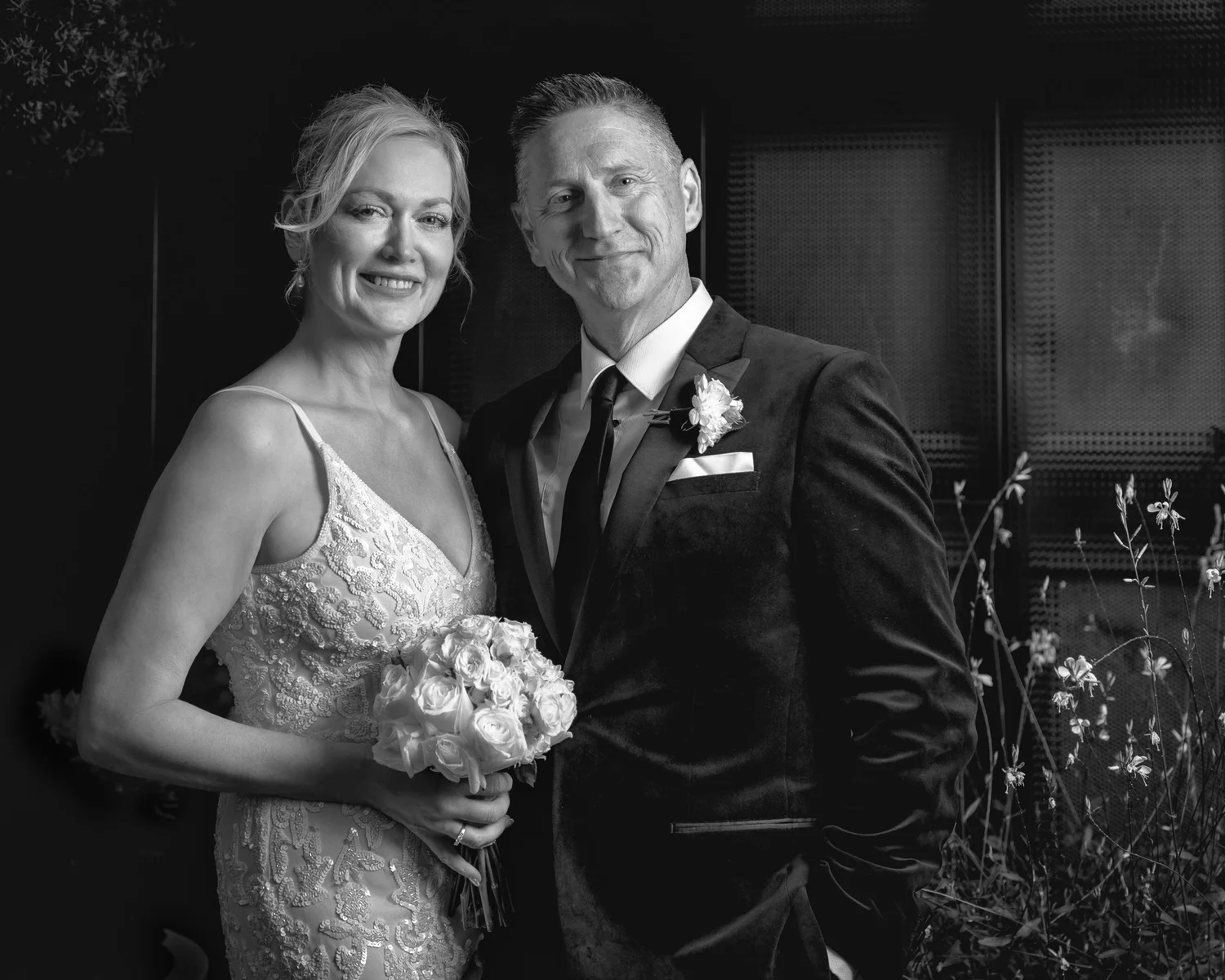 Black and white photo of Shannon holding her bouquet beside Darren