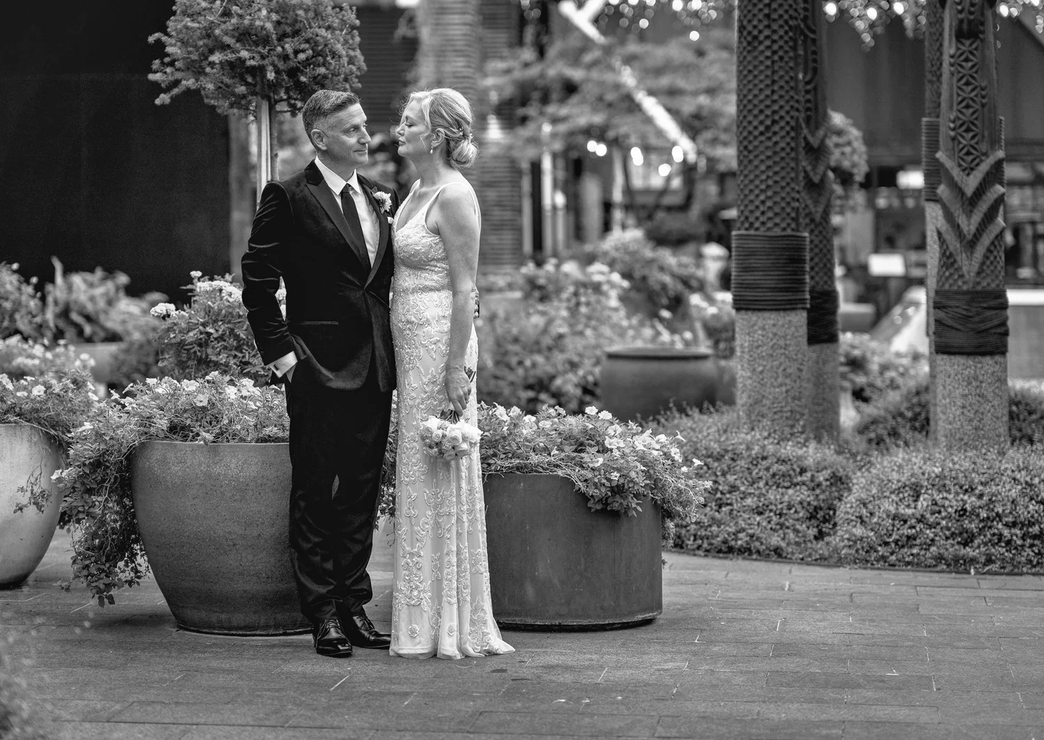 Black and white photo of the couple among potted plants