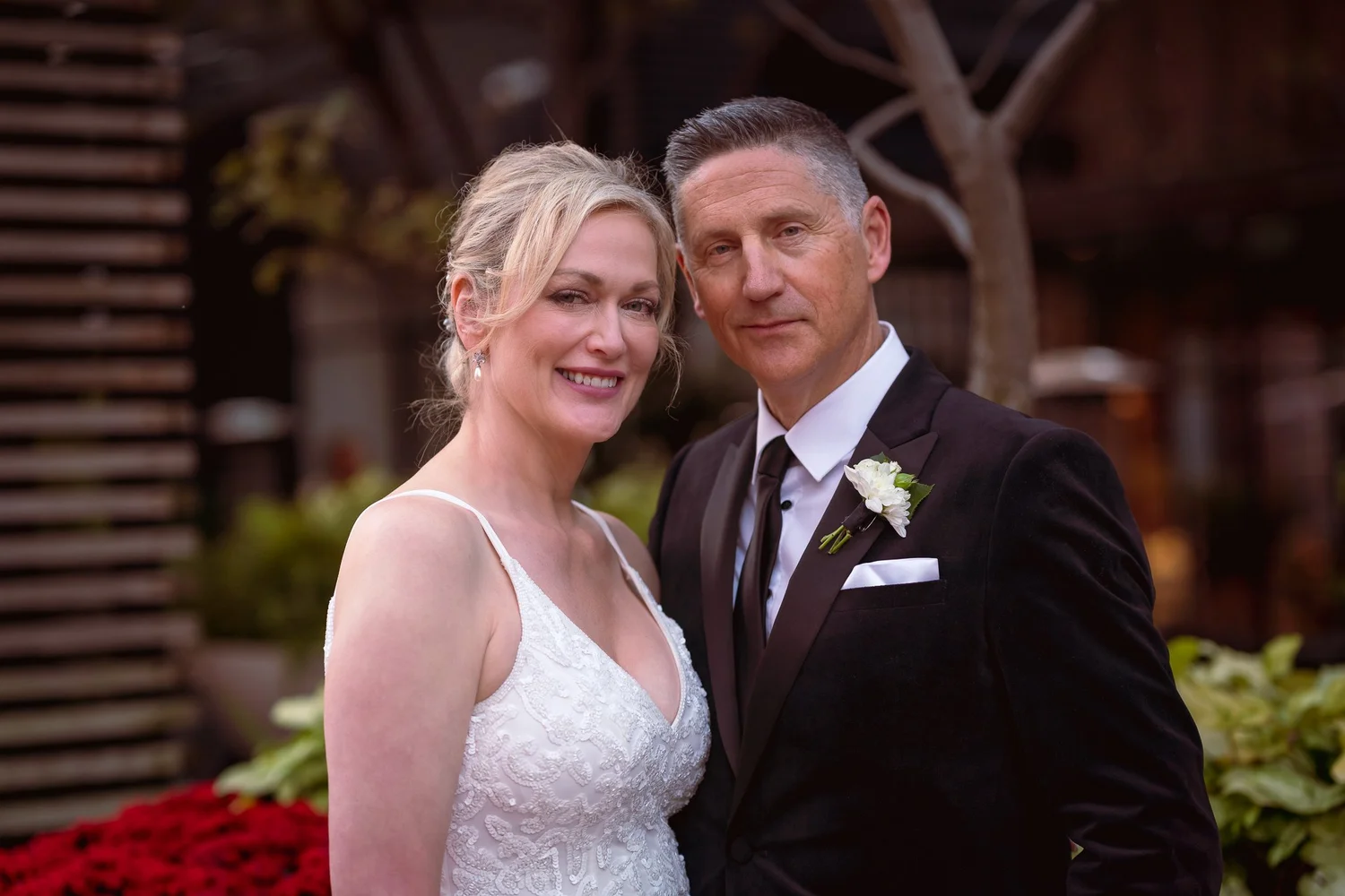 Shannon and Darren smile among red flowers