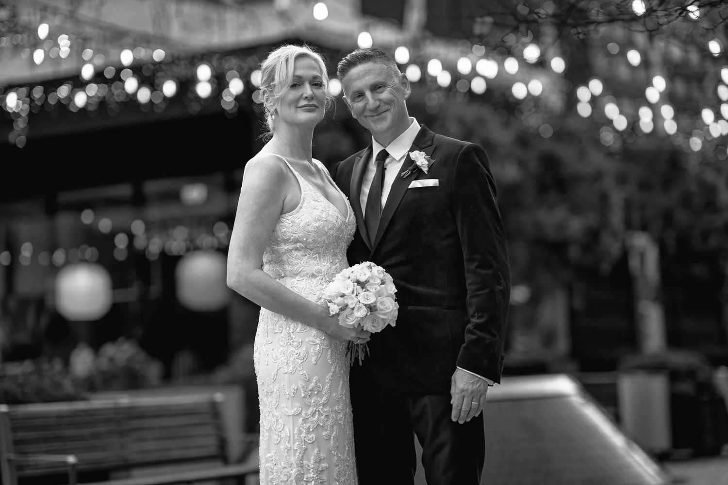 Black and white photo of the couple under festoon lights
