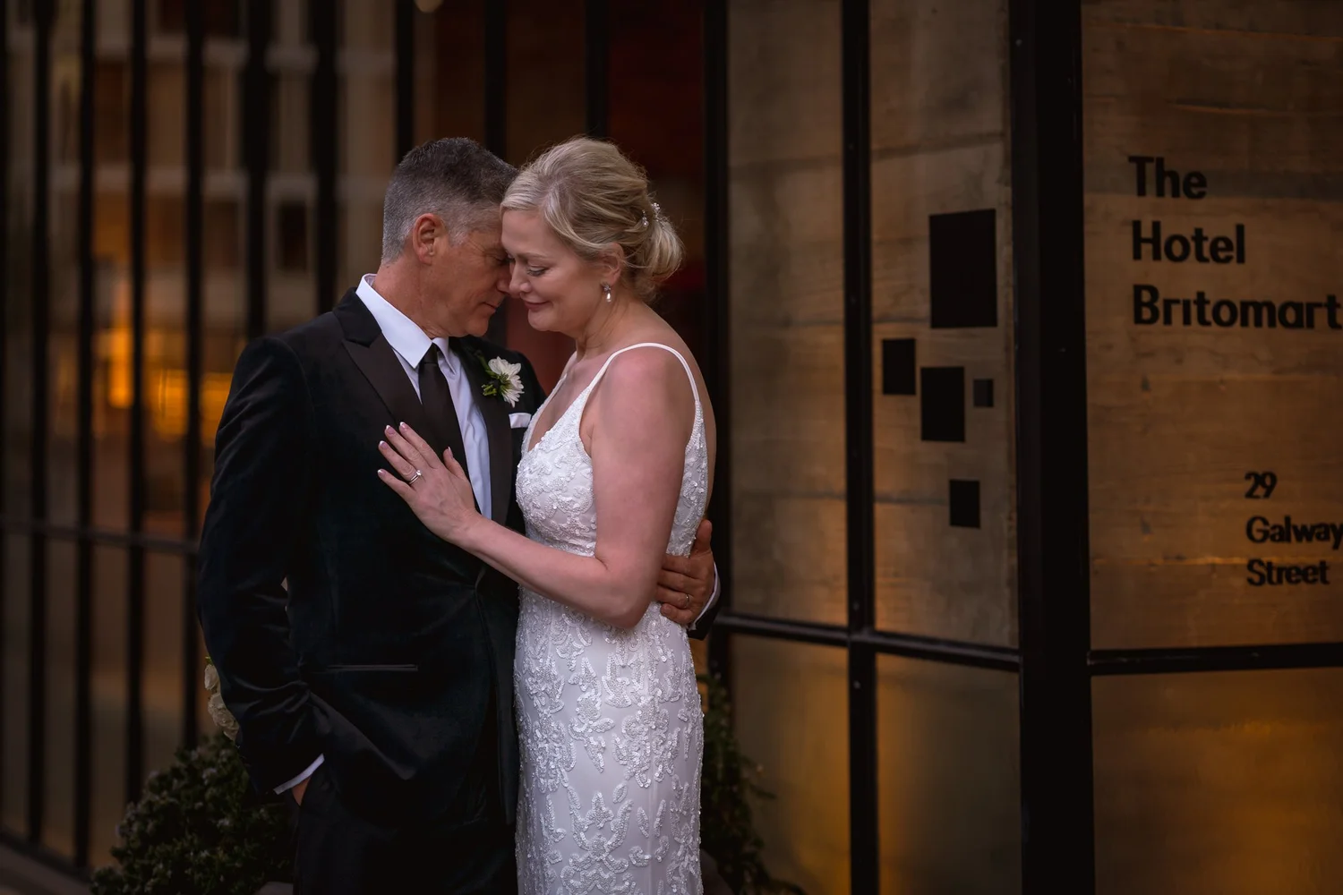 Shannon and Darren embrace by the hotel entrance