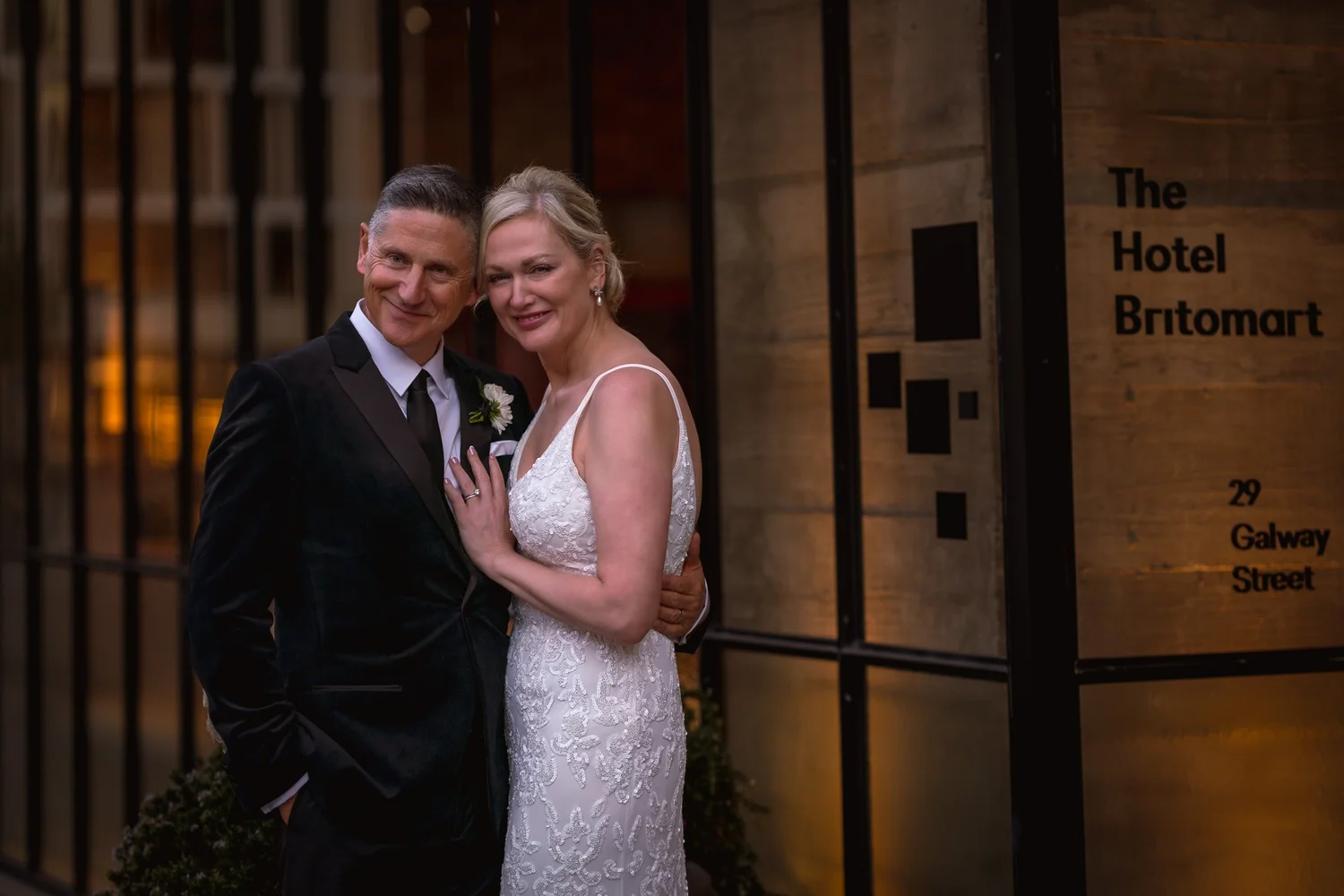 Shannon and Darren smile by the hotel sign
