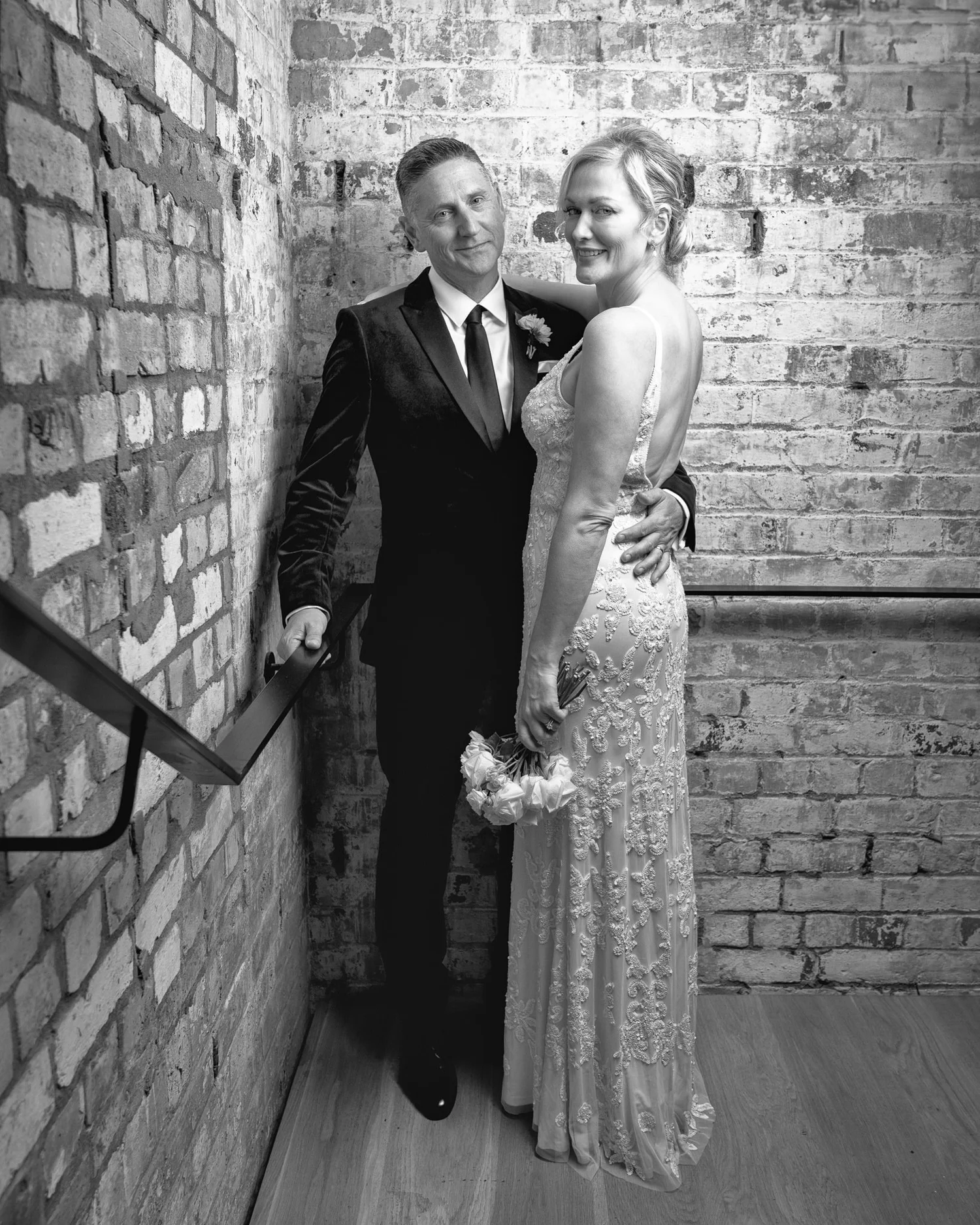 Black and white photo of the couple on a brick stairwell