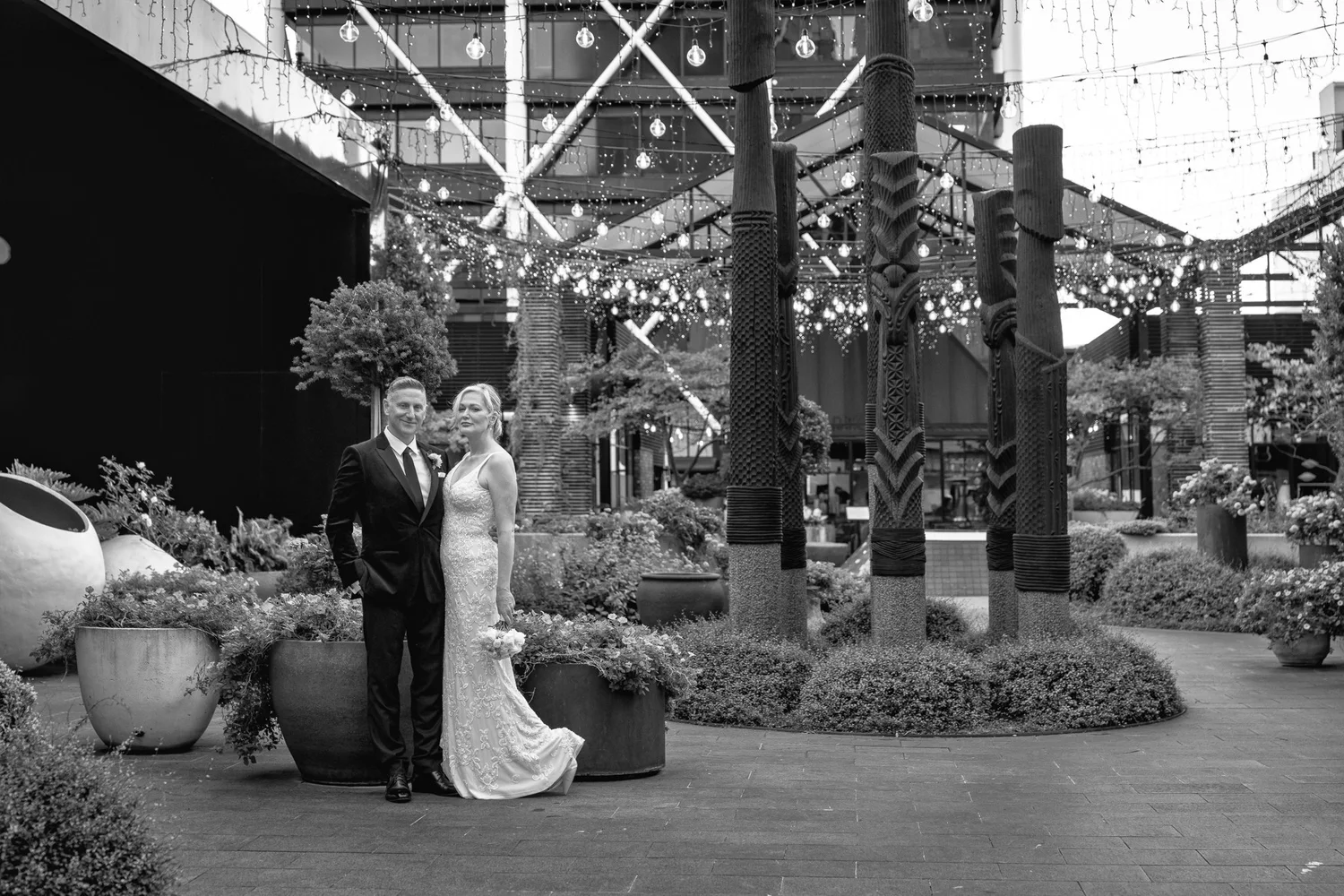 Black and white photo of the couple beneath carved pillars
