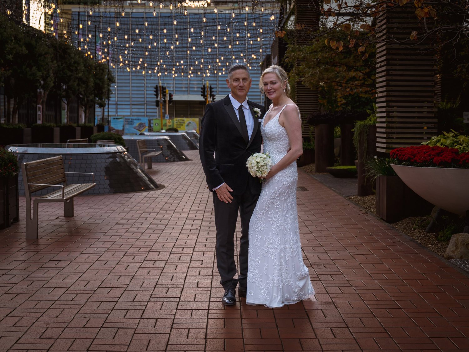 Shannon and Darren on the brick plaza with lights strung above