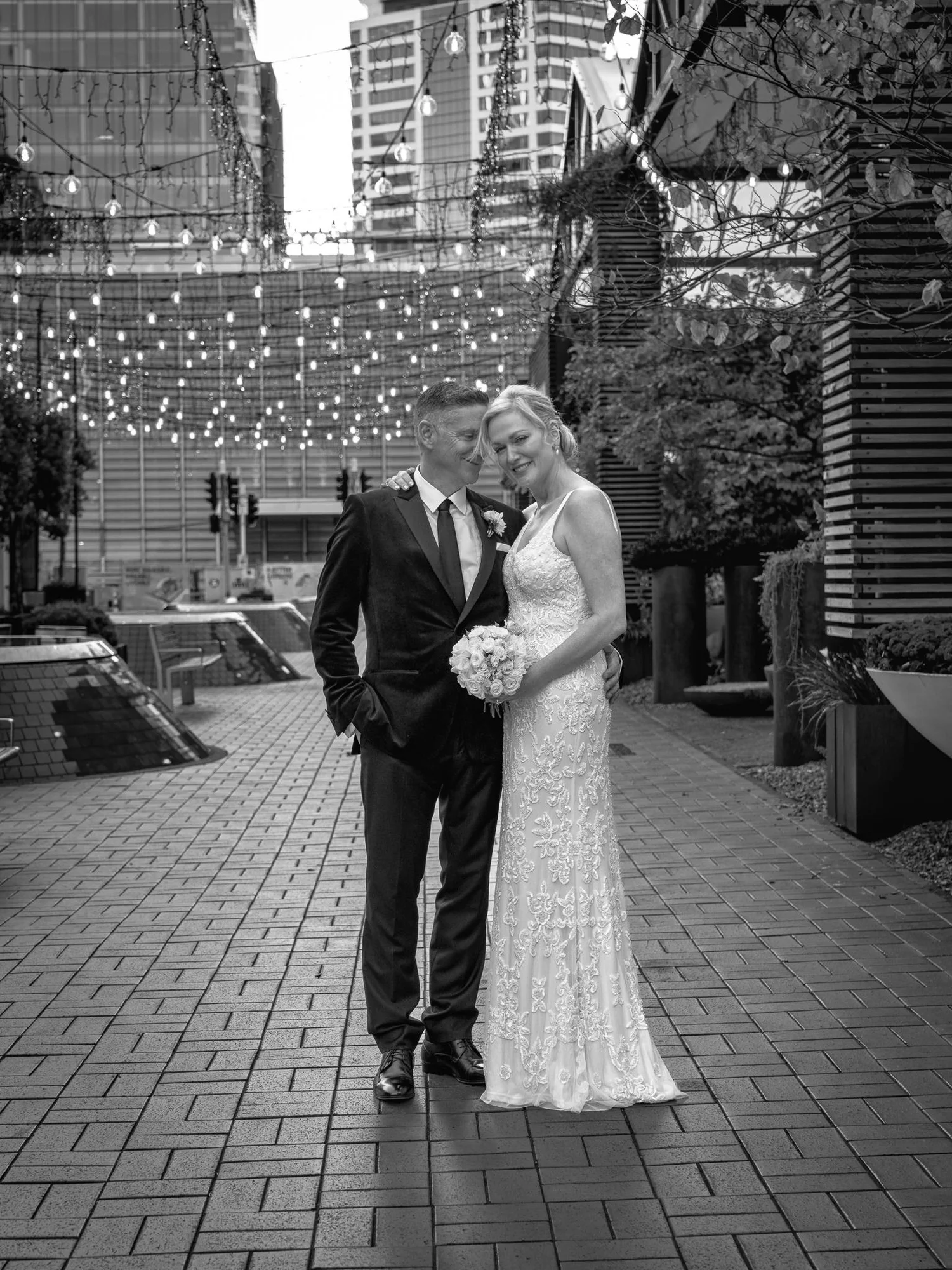 Black and white photo of the couple with city towers behind