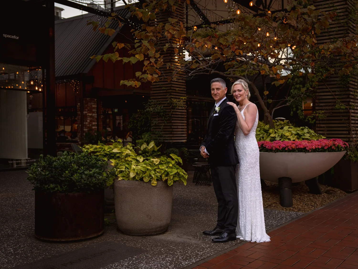 Shannon and Darren in the courtyard beneath autumn trees