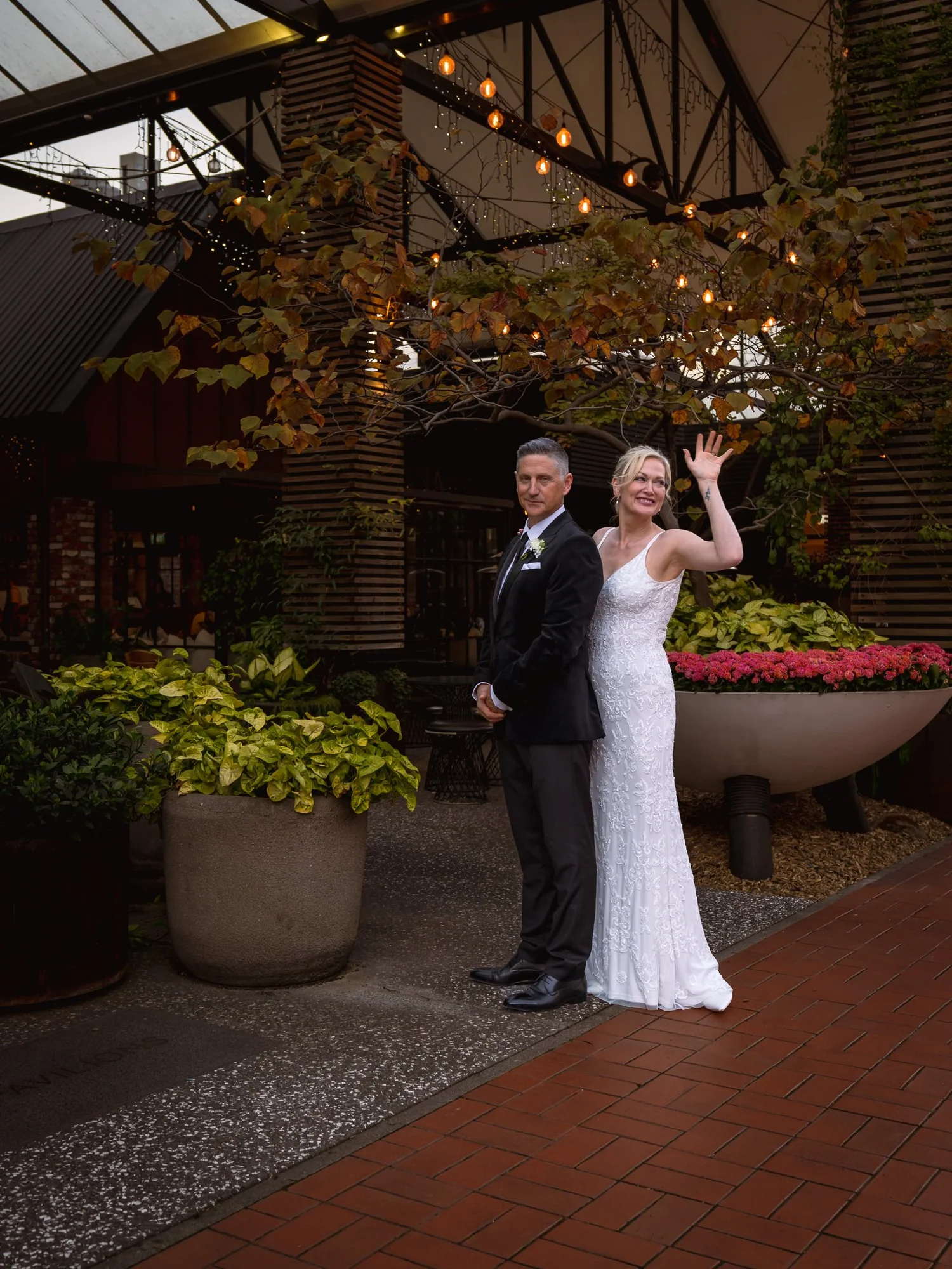 Shannon waves beside Darren in the courtyard