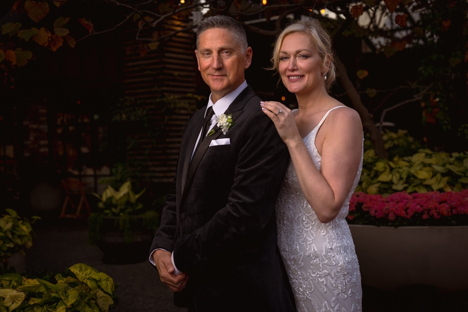 Shannon rests her hand on Darren's shoulder among the planters