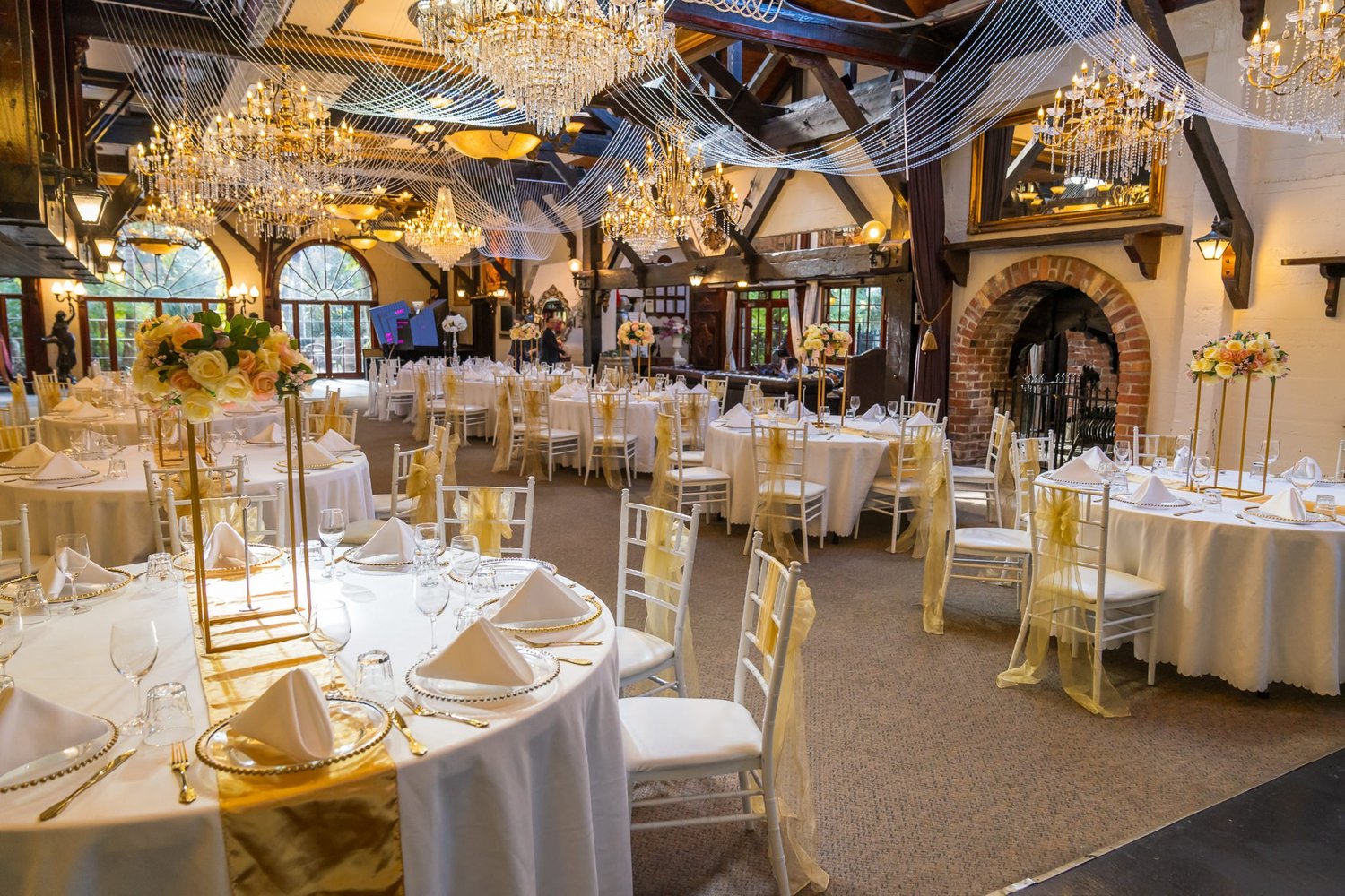 The reception room at Settlers Country Manor set with chandeliers and gold accents