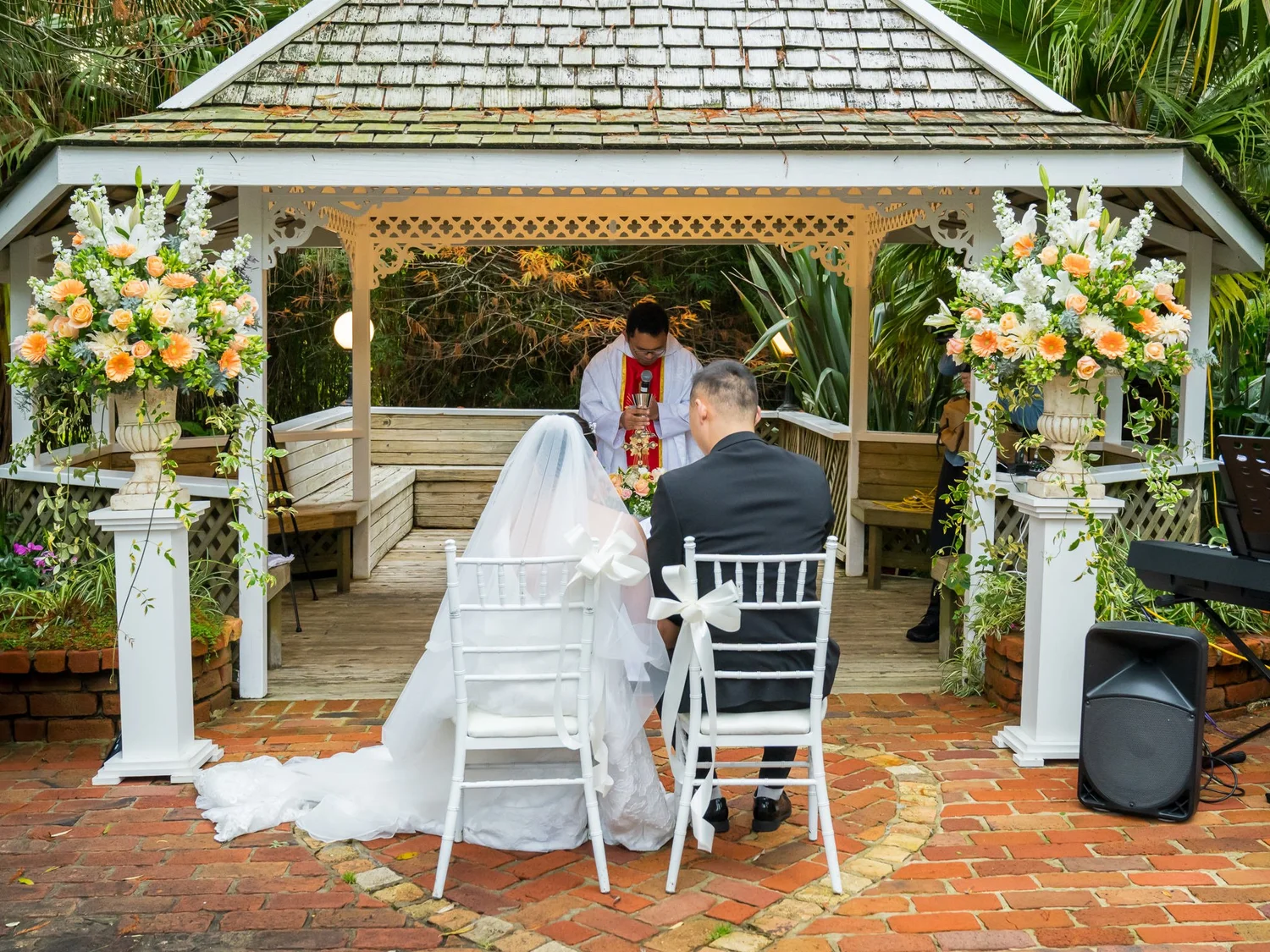 Stephanie and Jankai seated before the gazebo during the ceremony