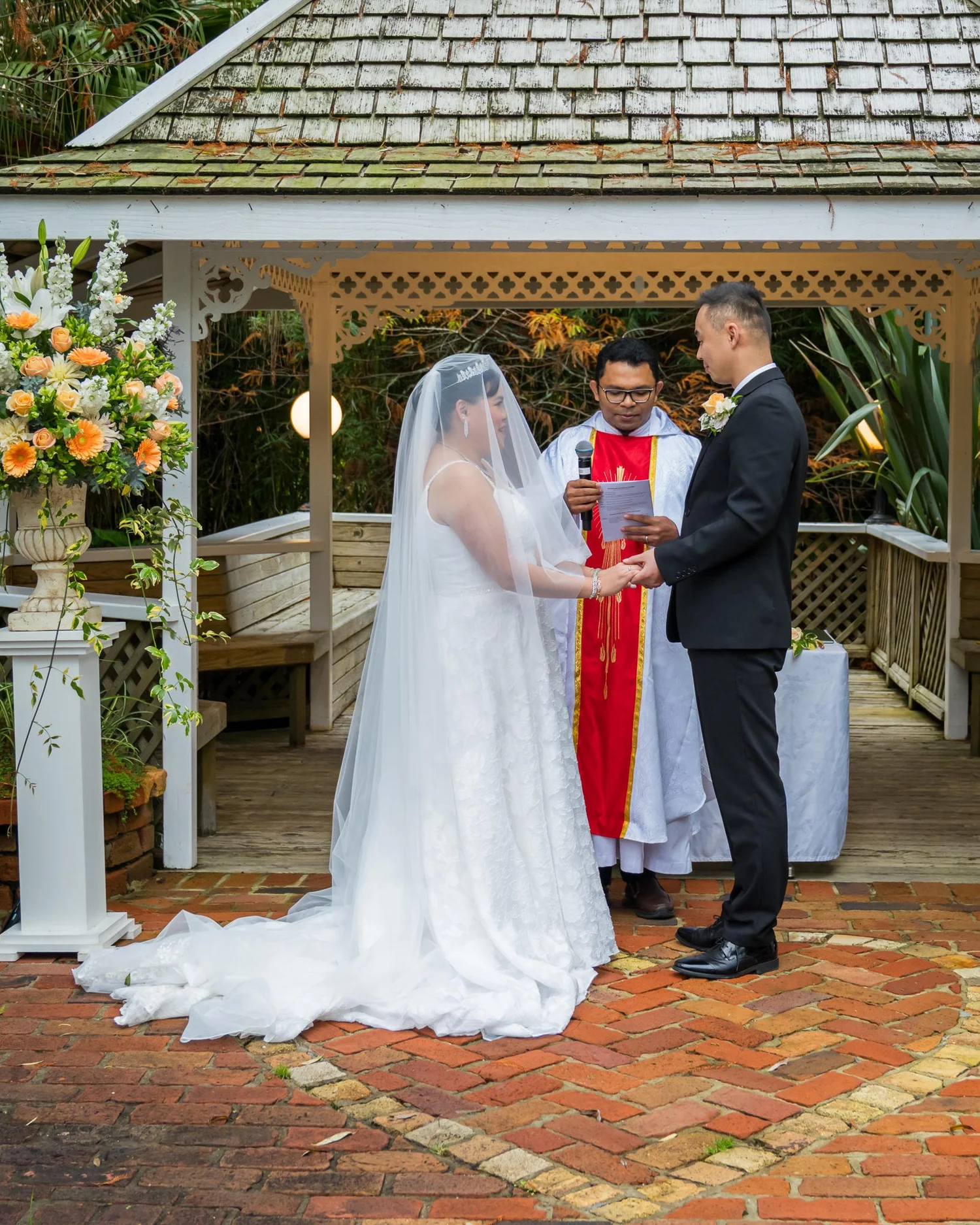 Stephanie and Jankai with the priest under the gazebo