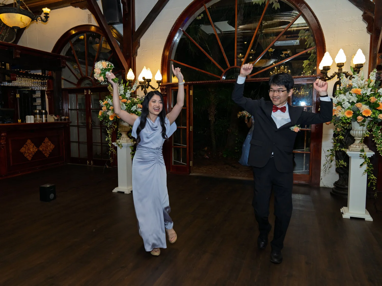 Members of the bridal party cheer as they enter the reception