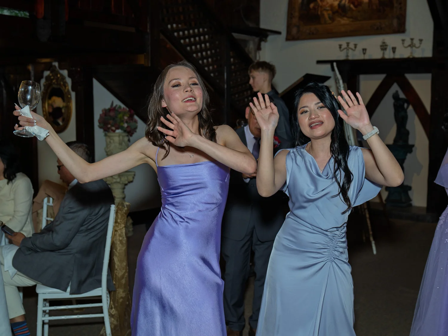 Two guests dance with their hands in the air