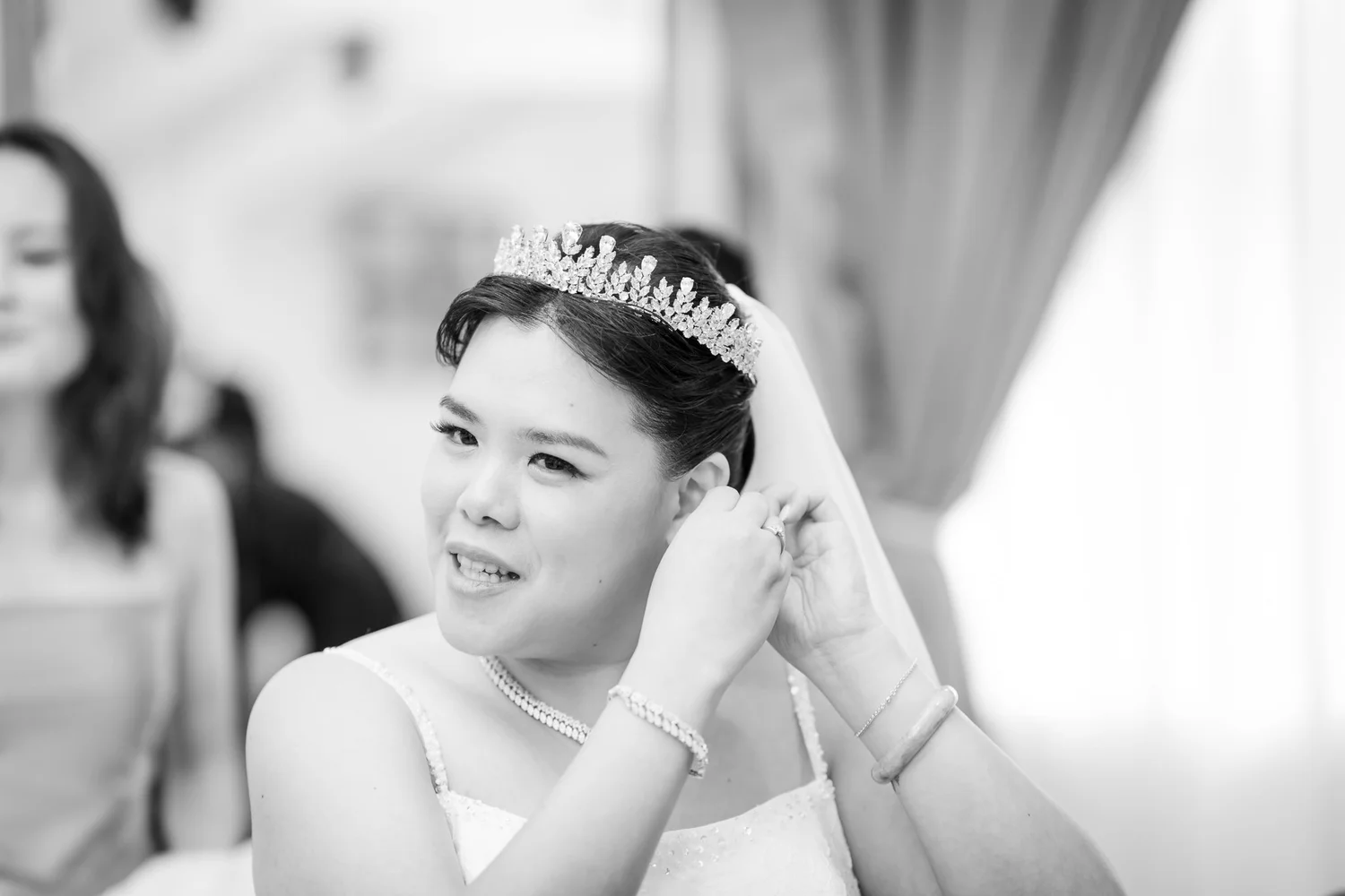Black and white photo of Stephanie fastening her earring