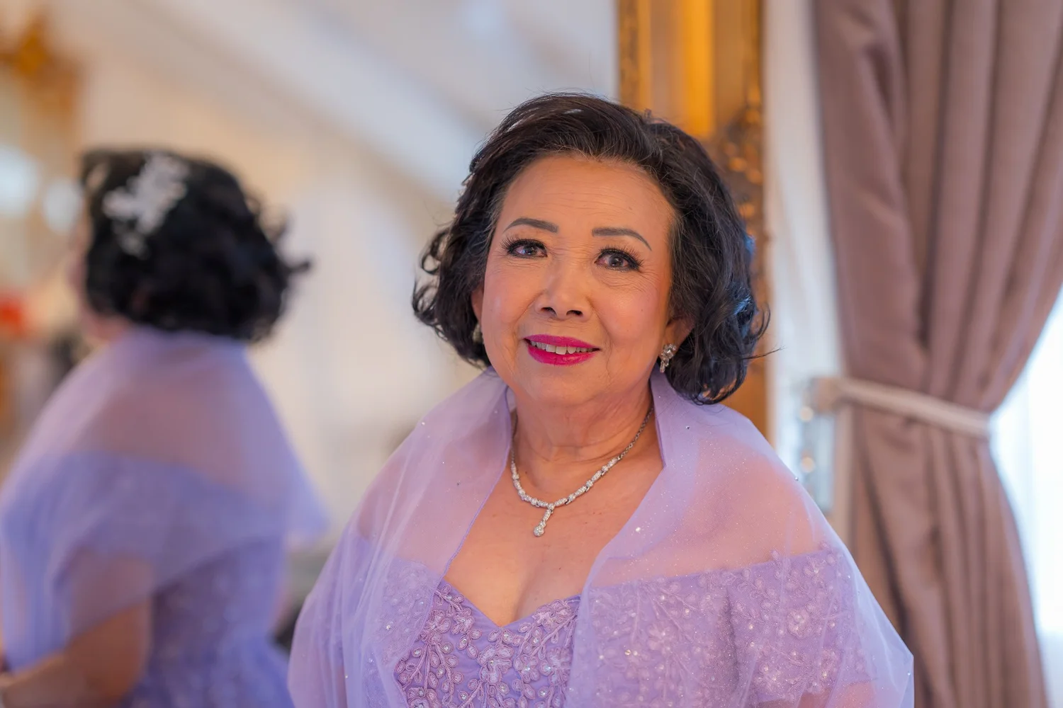 A guest in lilac smiles during preparations