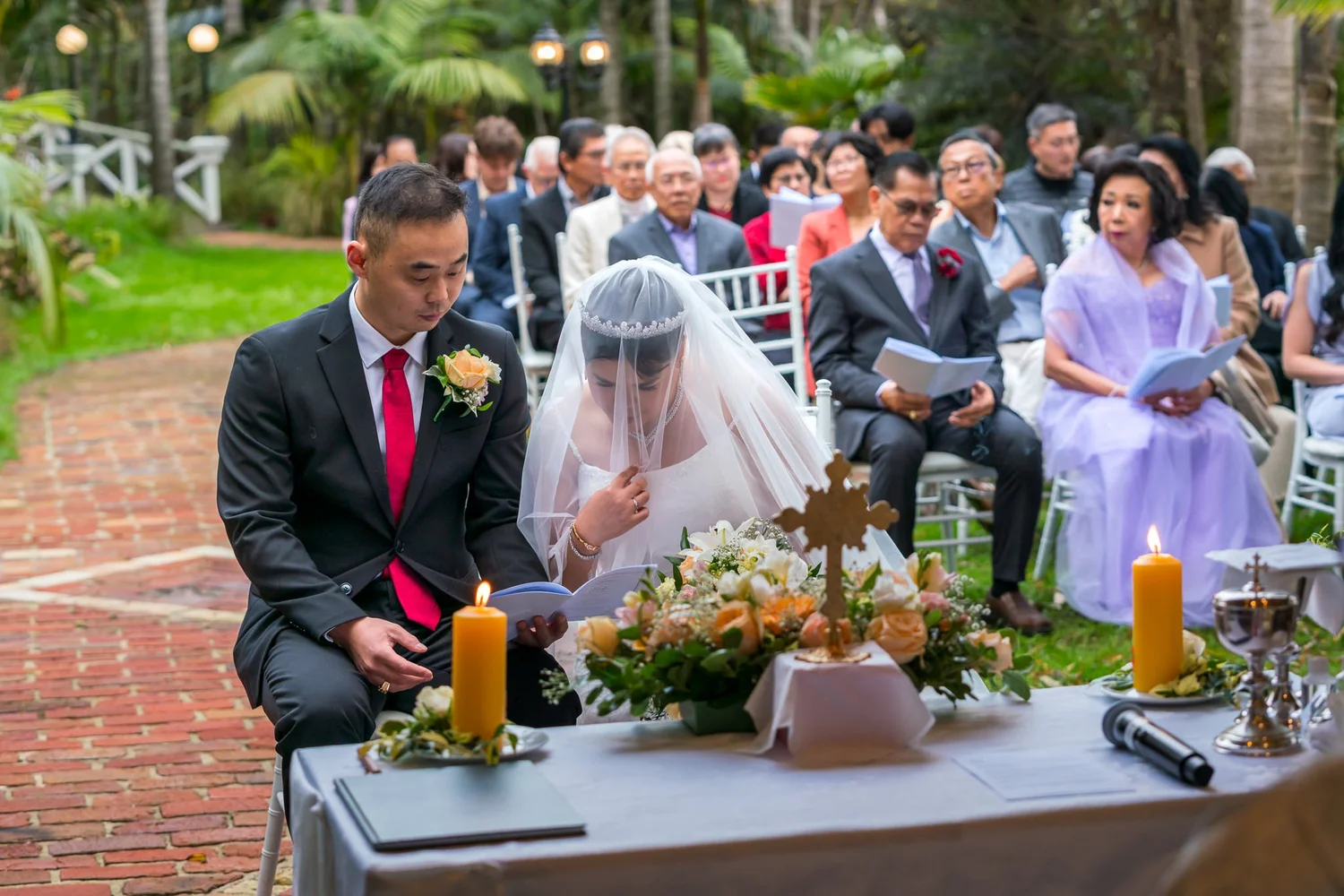 Stephanie and Jankai at the ceremony table with a lit candle