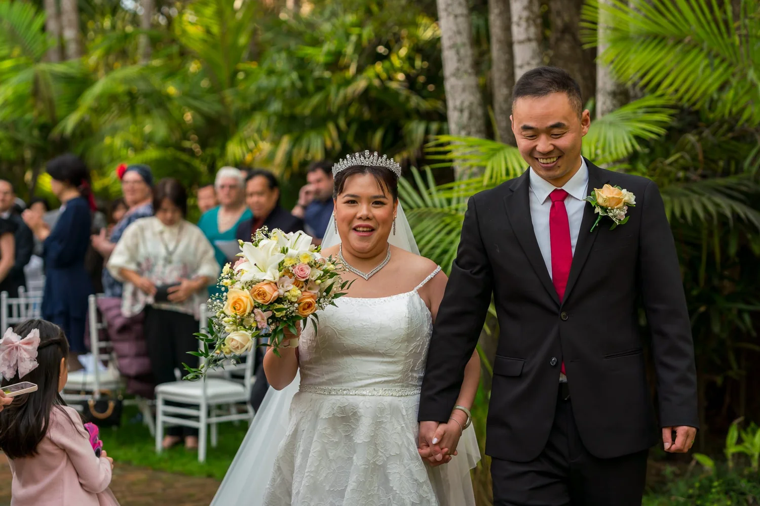 Stephanie and Jankai smile as they walk past guests
