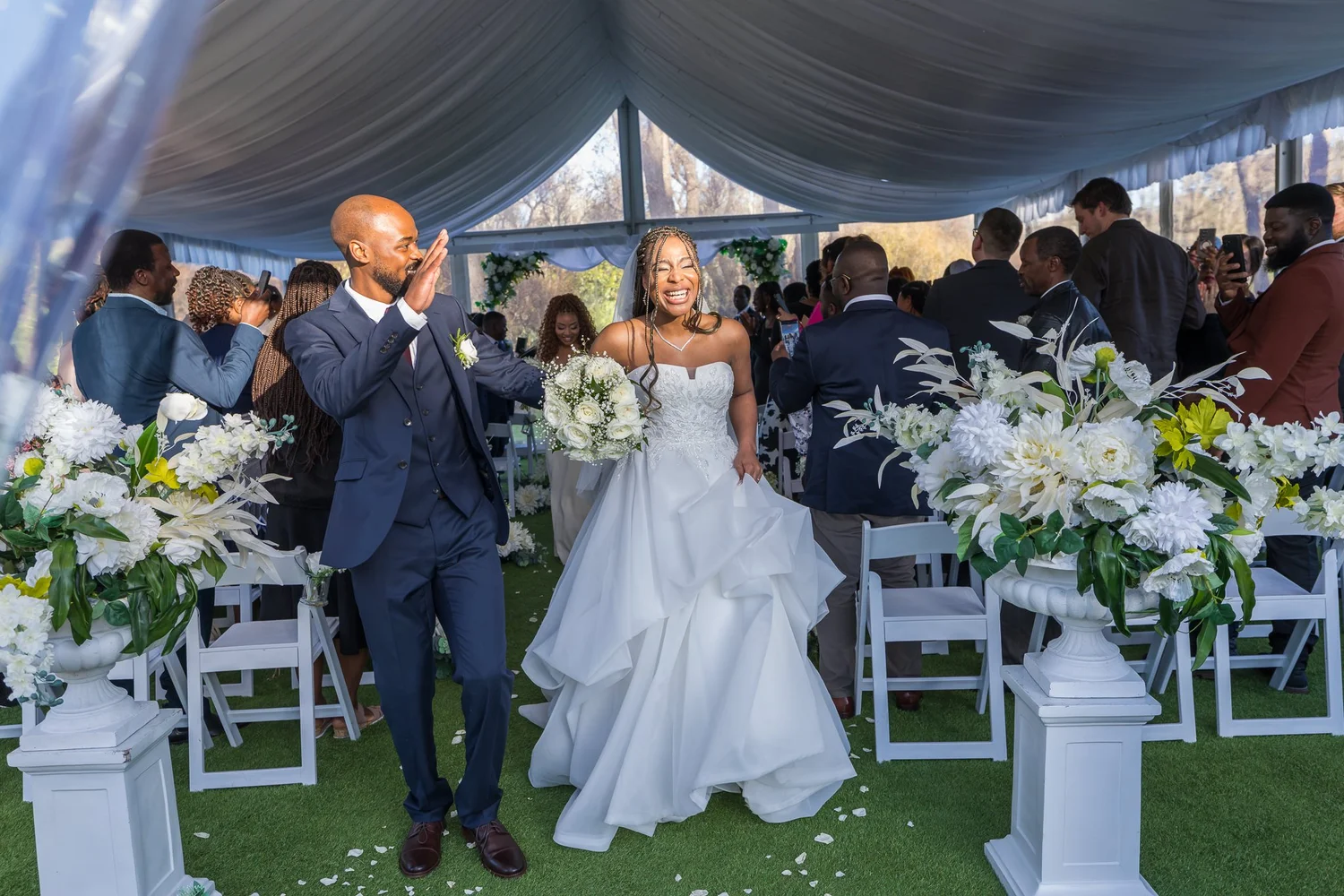 Chiedza and Foster celebrate as they walk up the aisle at Abel Estate